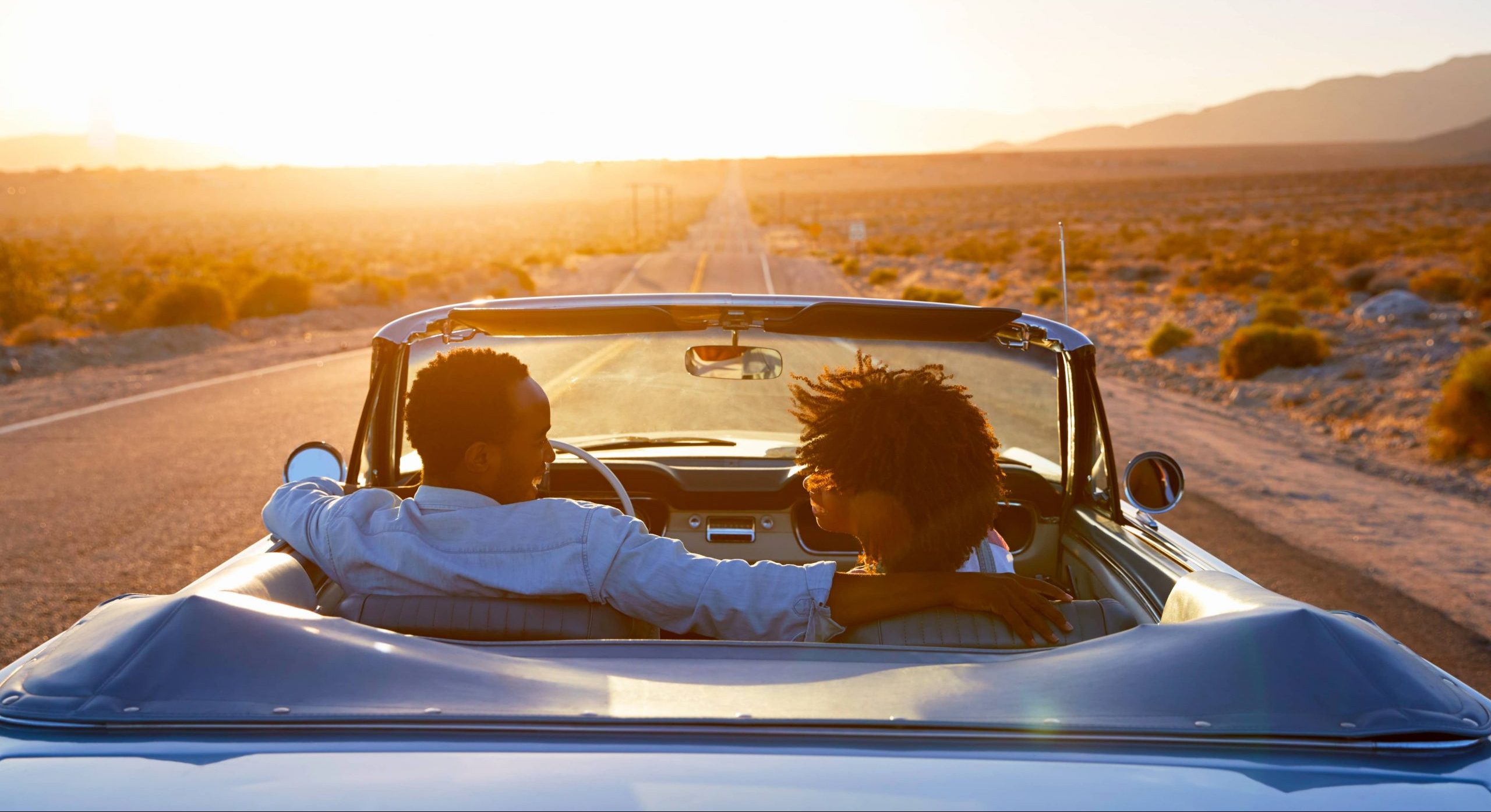 Two friends enjoying the car ride on a sunny afternoon.