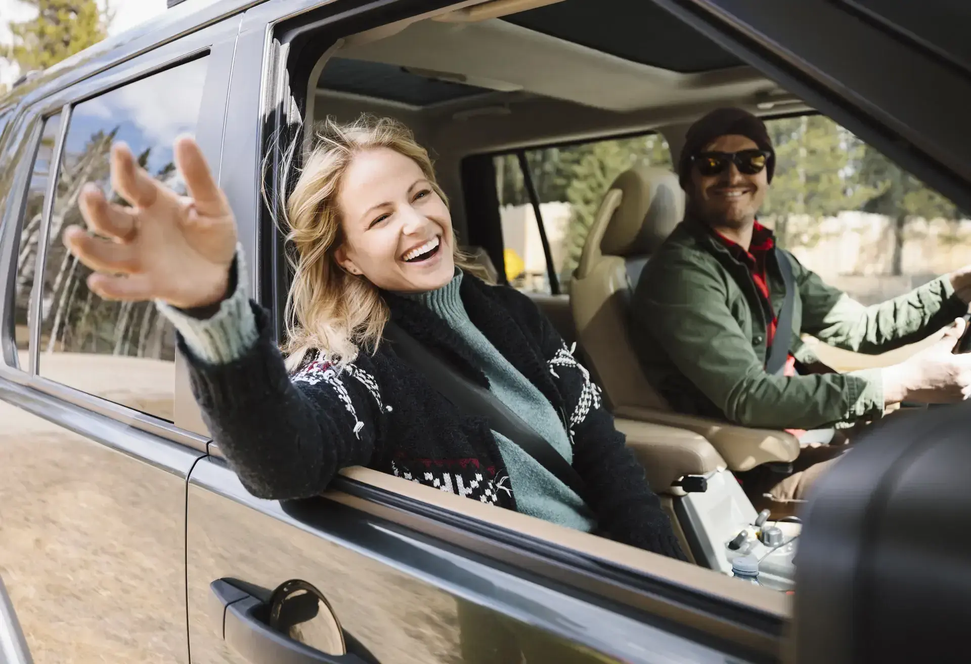 Carefree woman enjoying road trip in SUV