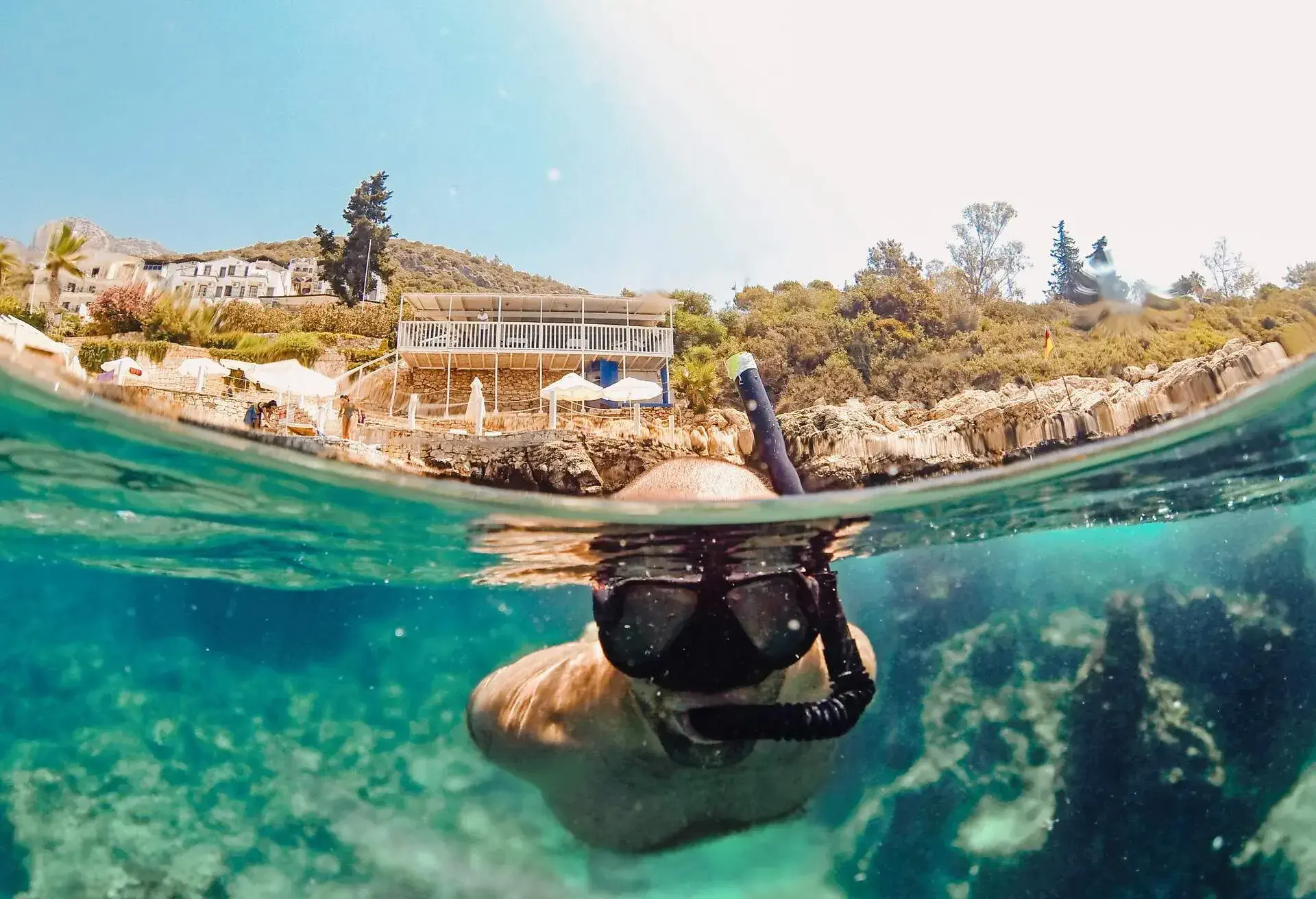 Man snorkelling in clear blue waters at the beach