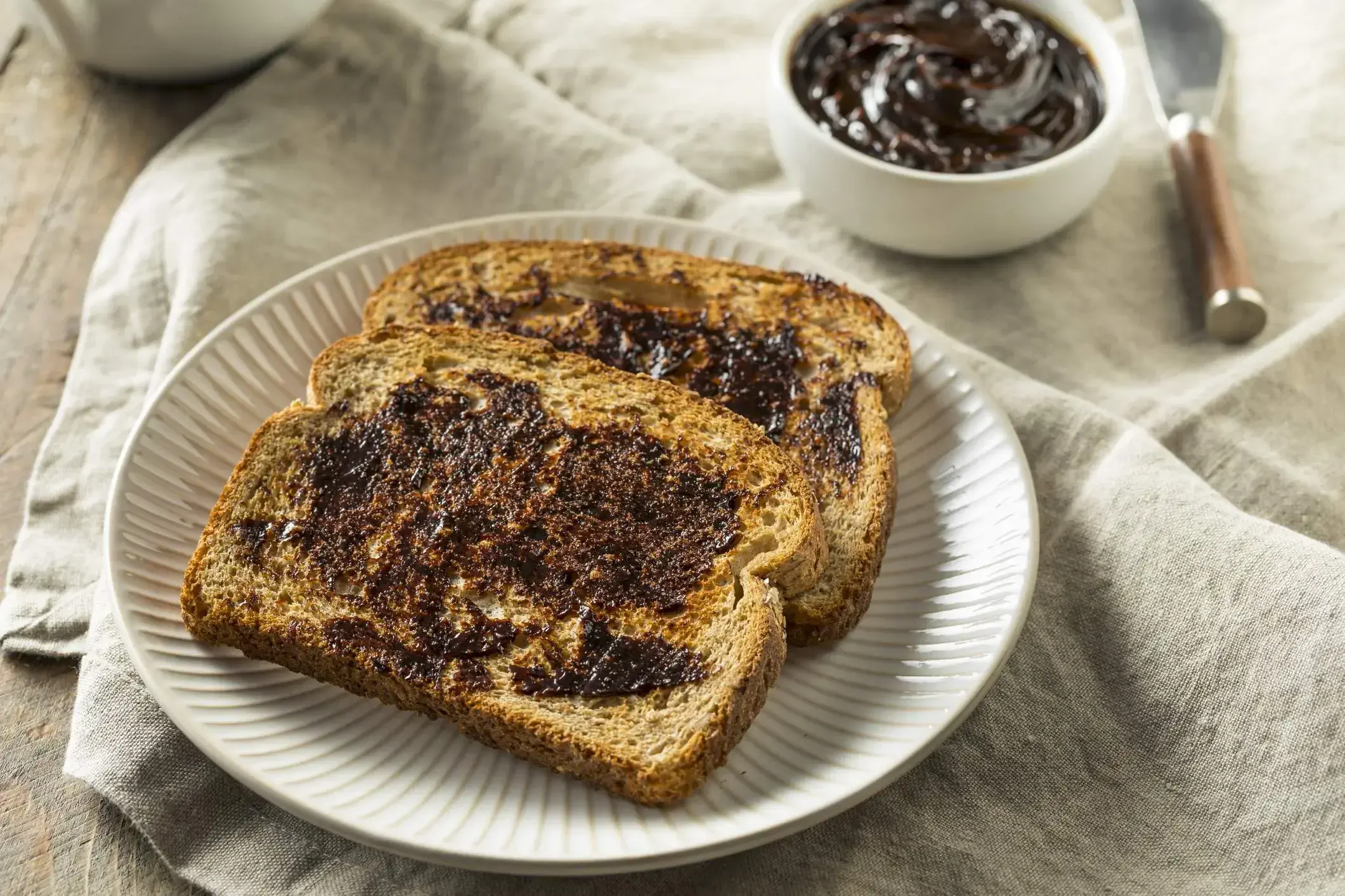 White plate with two slices of toast with vegemite