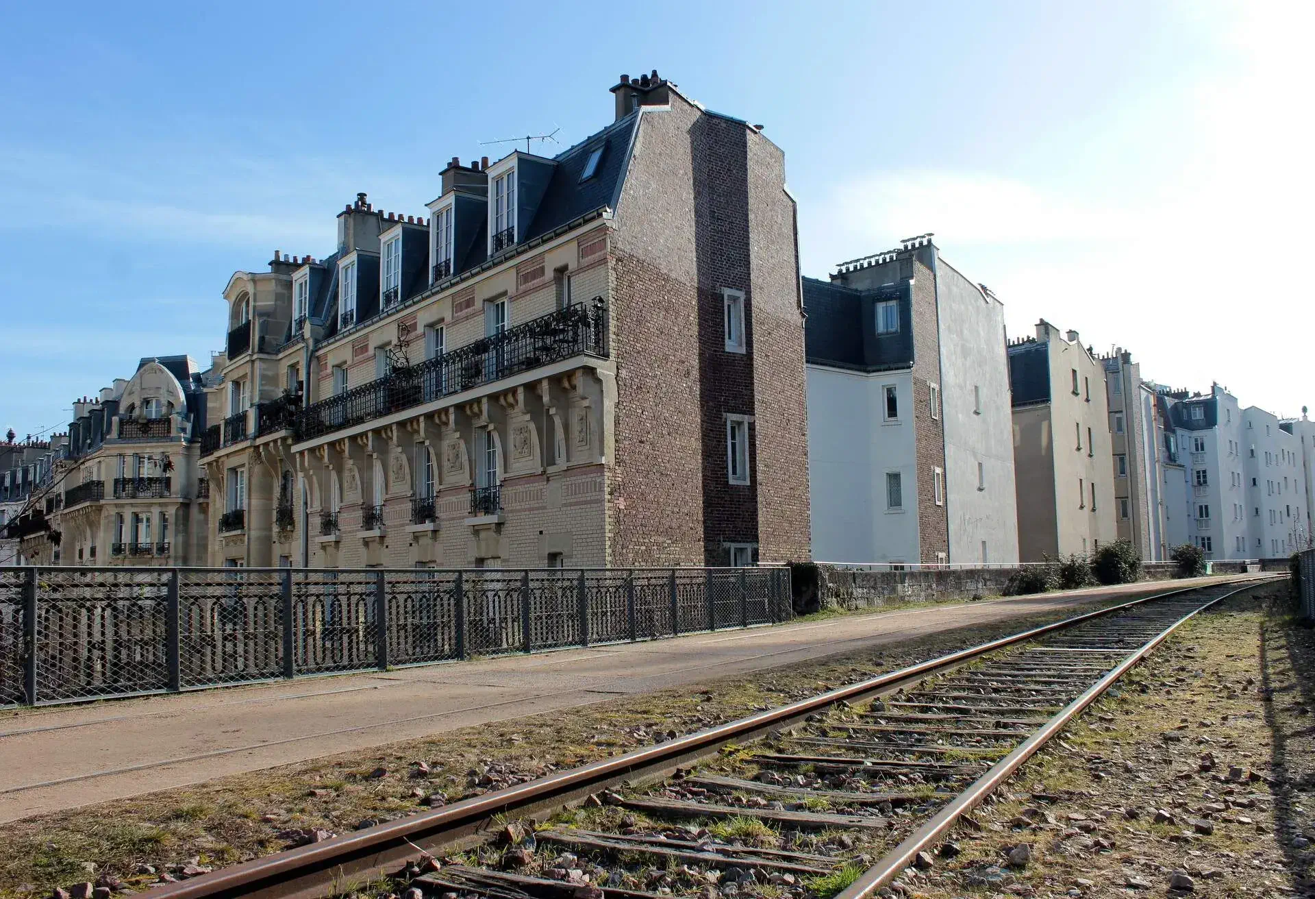 An abandoned railway next to some classic french buildings