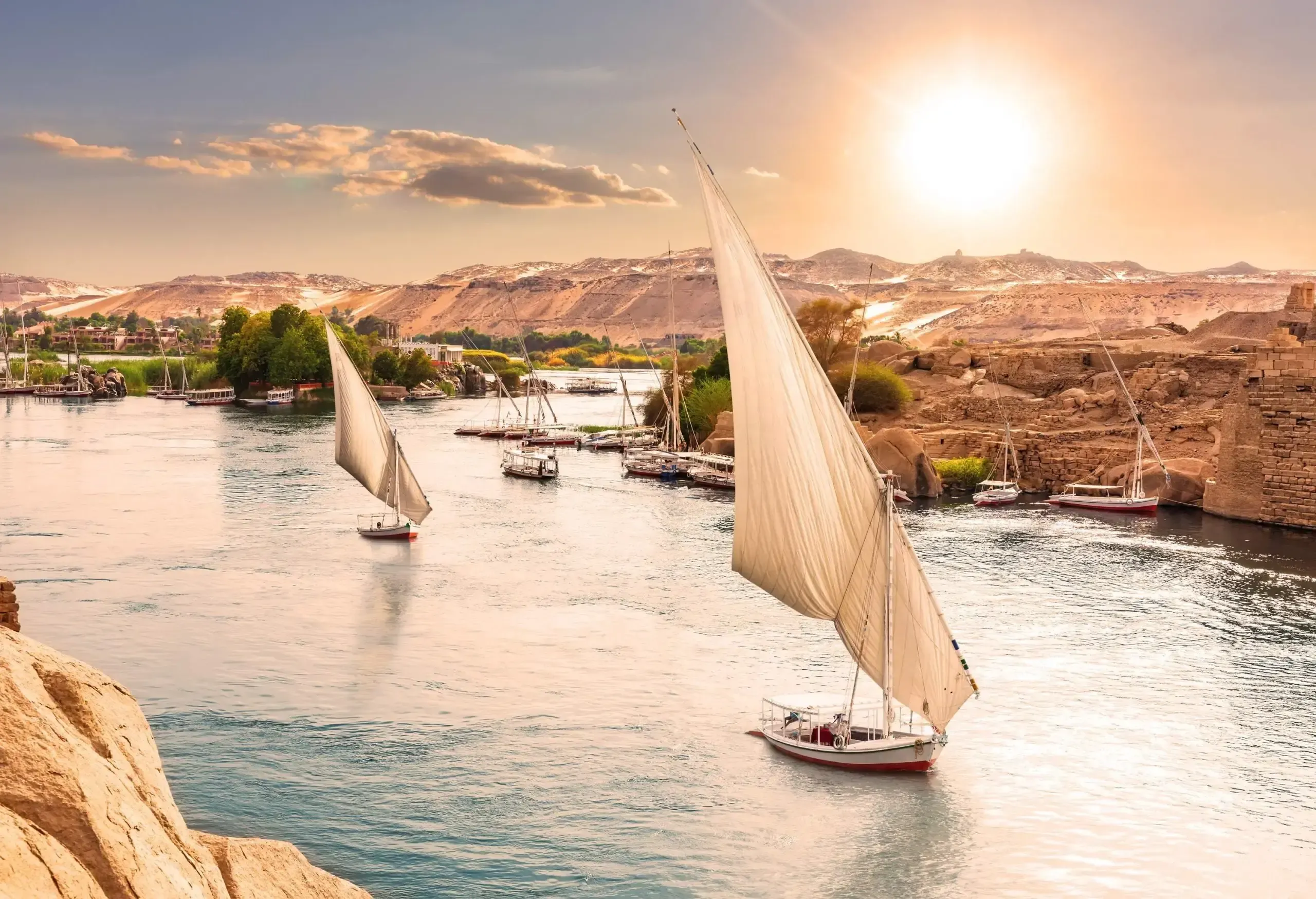 High angle view of sailboats on the river Nile on a sunny late afternoon with mountains and a port in the background