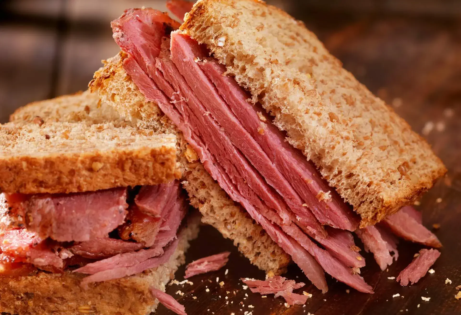 Canadian smoked beef sandwich cut in two halves on a wooden table