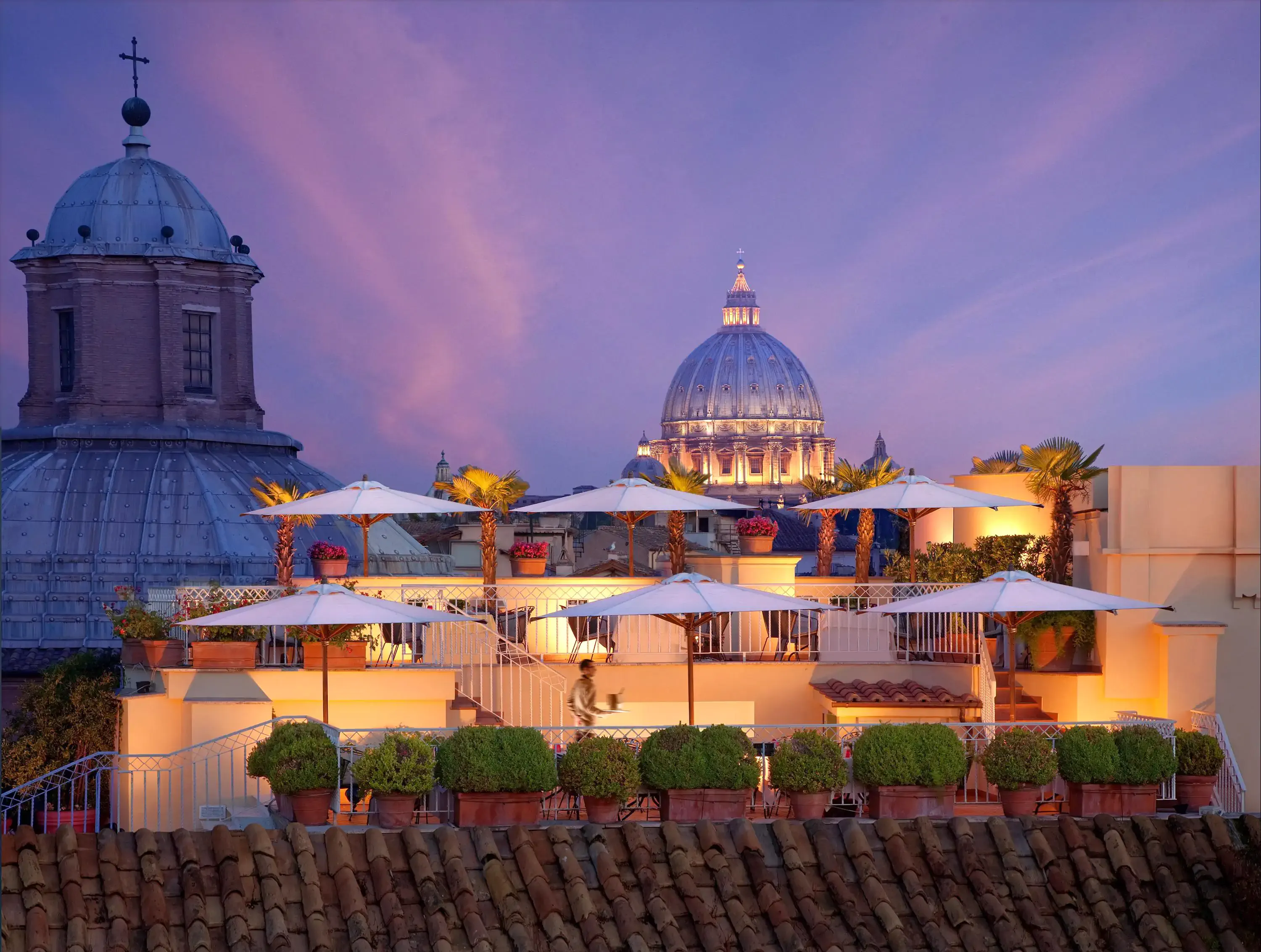 Roman rooftop restaurant at dusk with church chimes in the background
