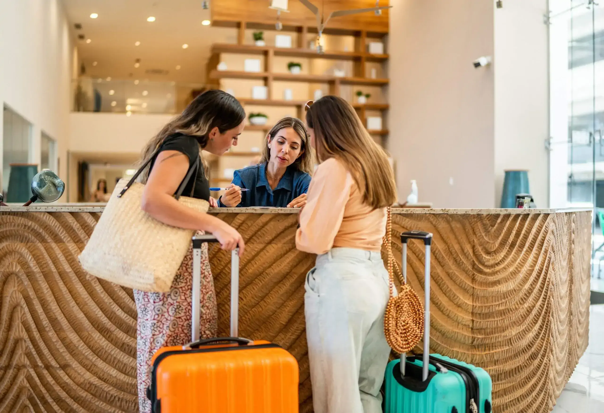 Hotel receptionist talking customers at lobby.