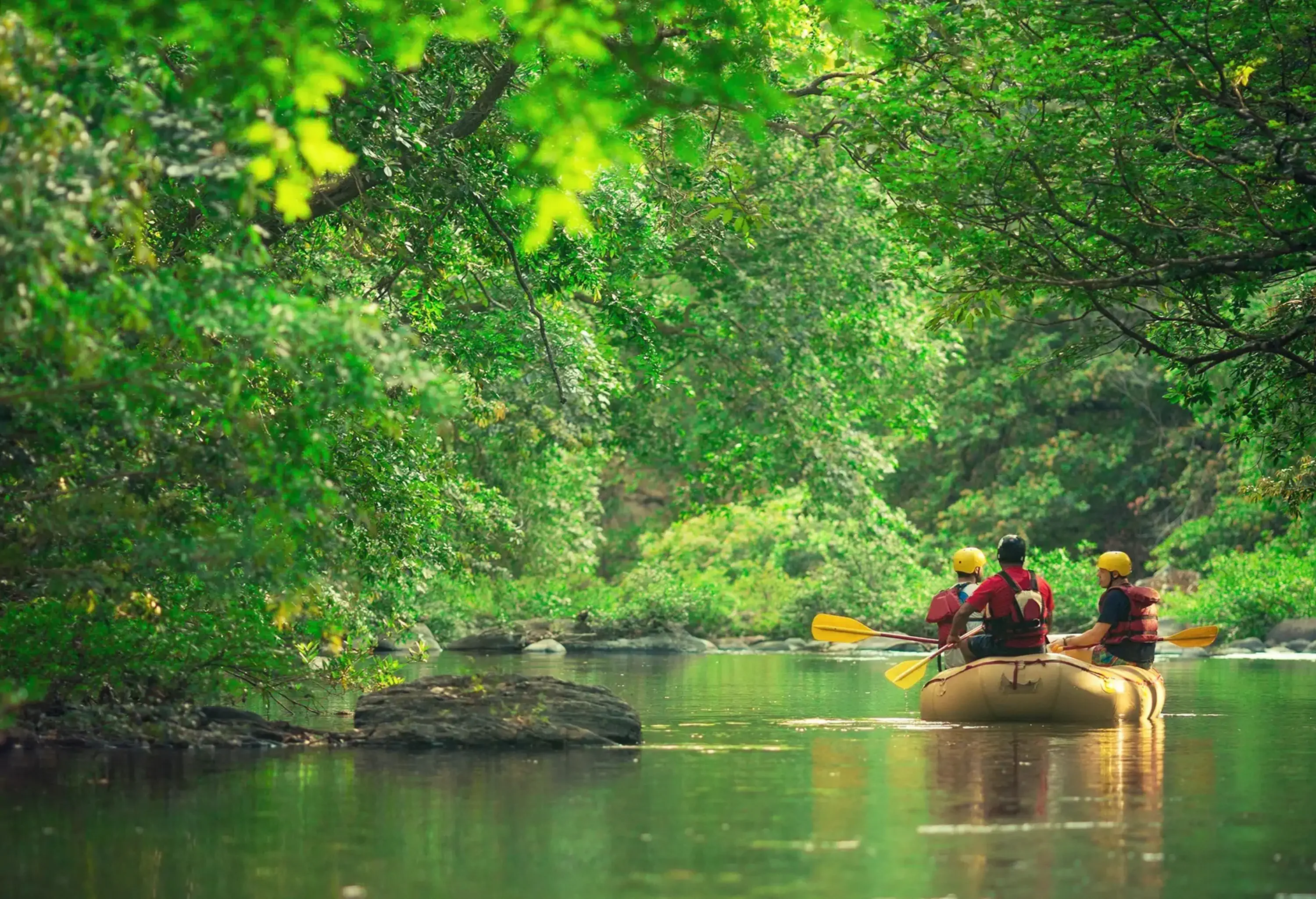 People on a boat experience tranquillity while enjoying a rafting adventure on a peaceful river.