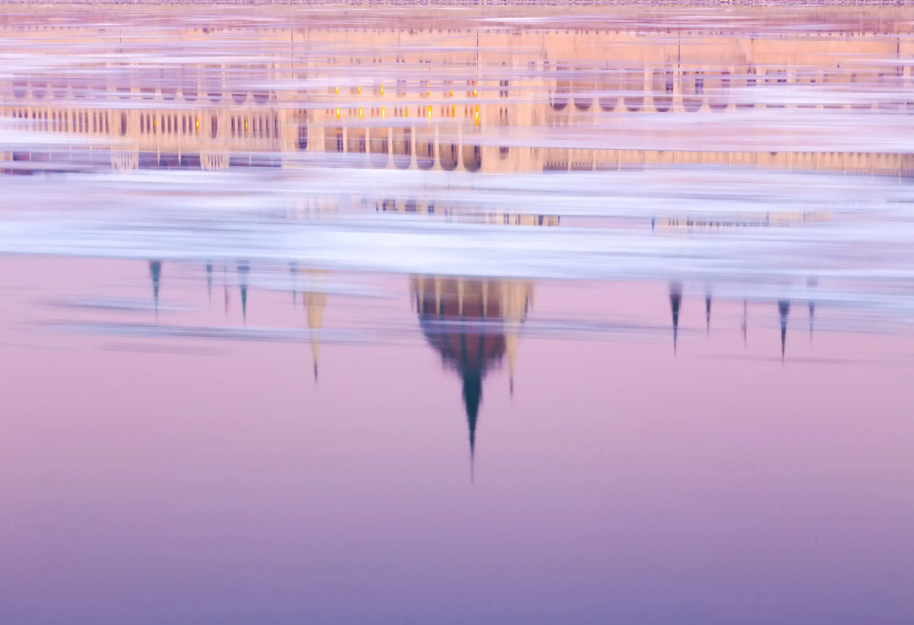 An upside-down reflection of a historic building on the water's surface.