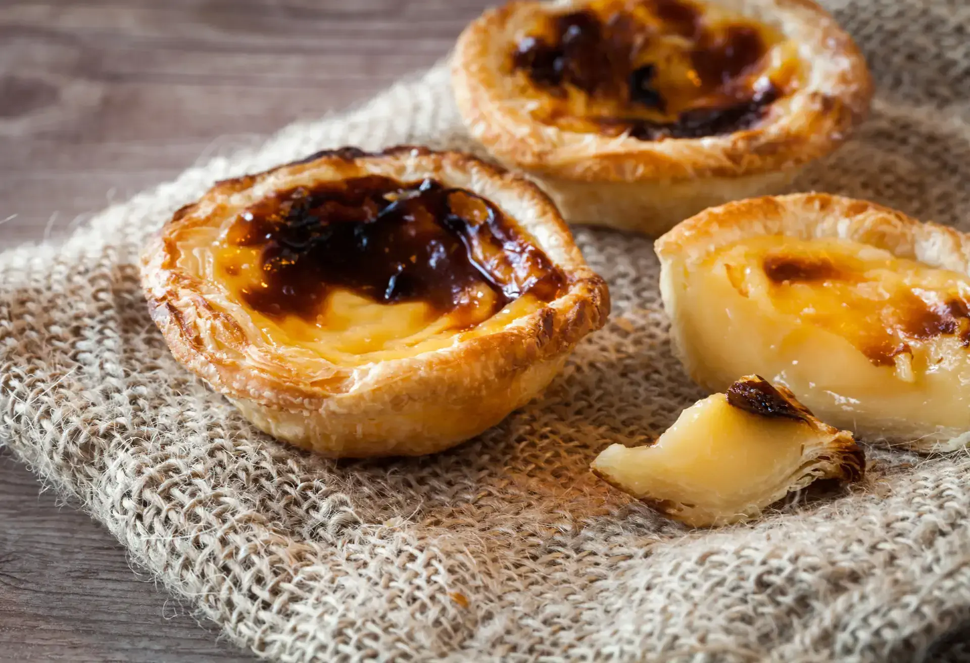 Pastel de Belém on a rough cloth and wooden table