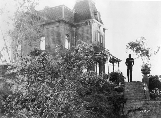 View of actor Anthony Perkins standing beside the Bates Motel in a still from the film, 'Psycho,' directed by Alfred Hitchcock, 1960. (Photo by Paramount Pictures/Courtesy of Getty Images)