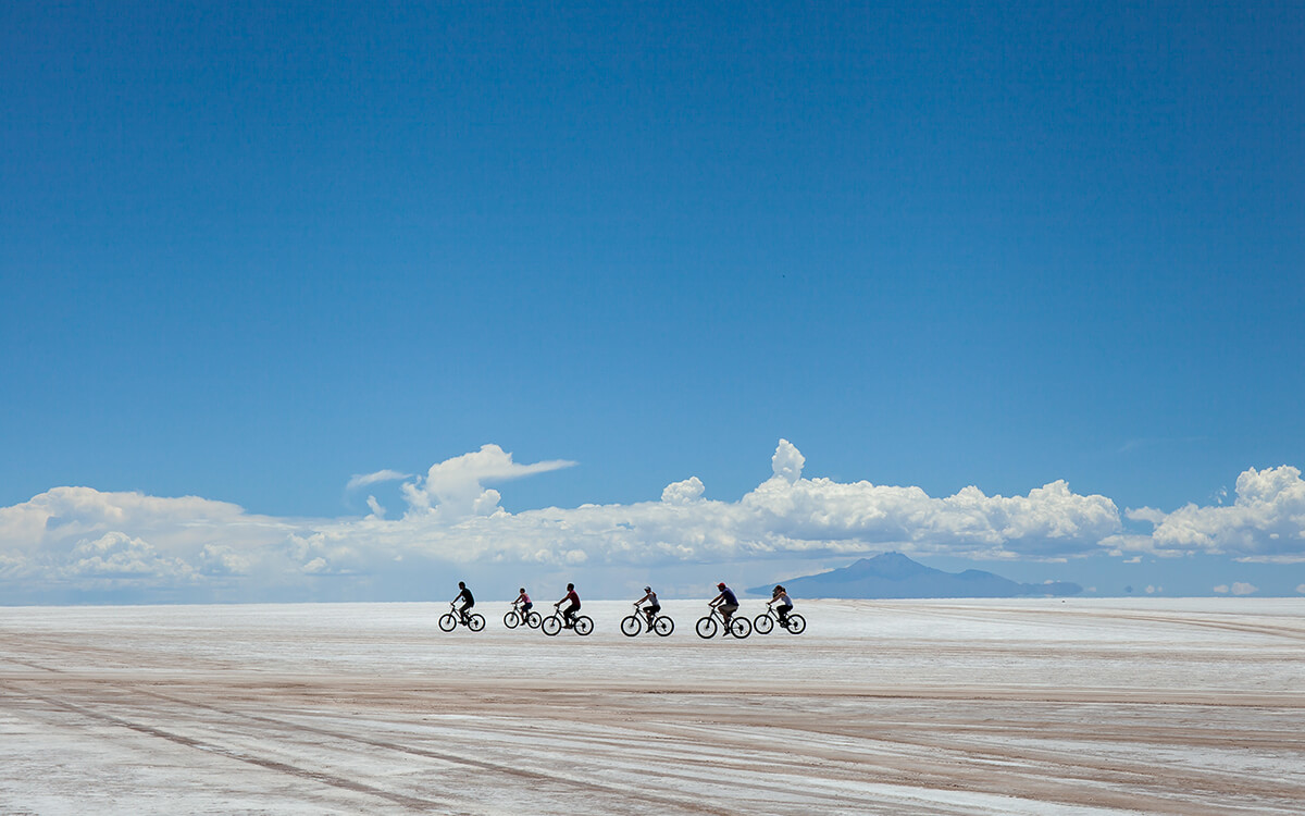 people cycling across salt flats