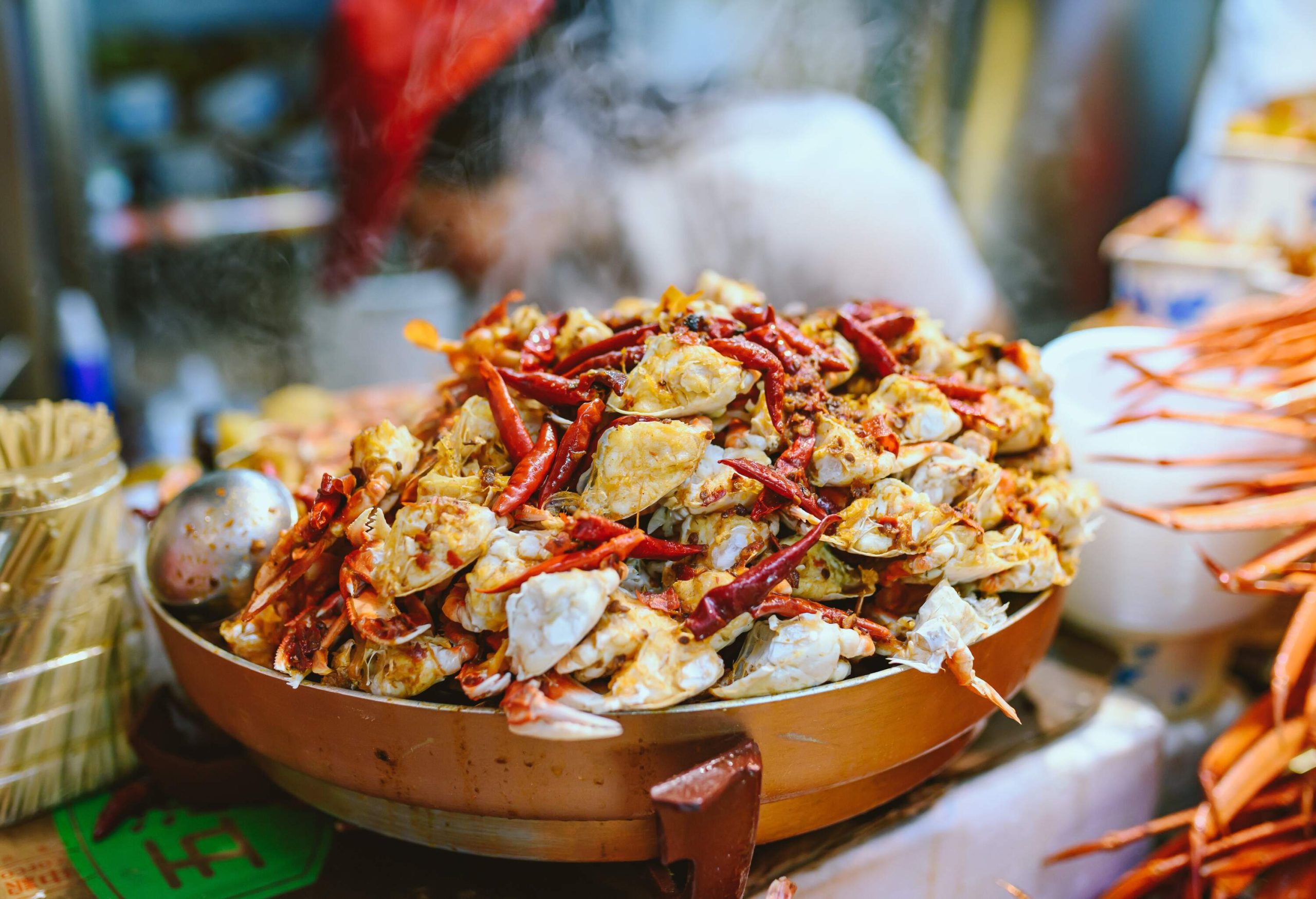 A bowl full of overflowing and steaming open mini crabs.
