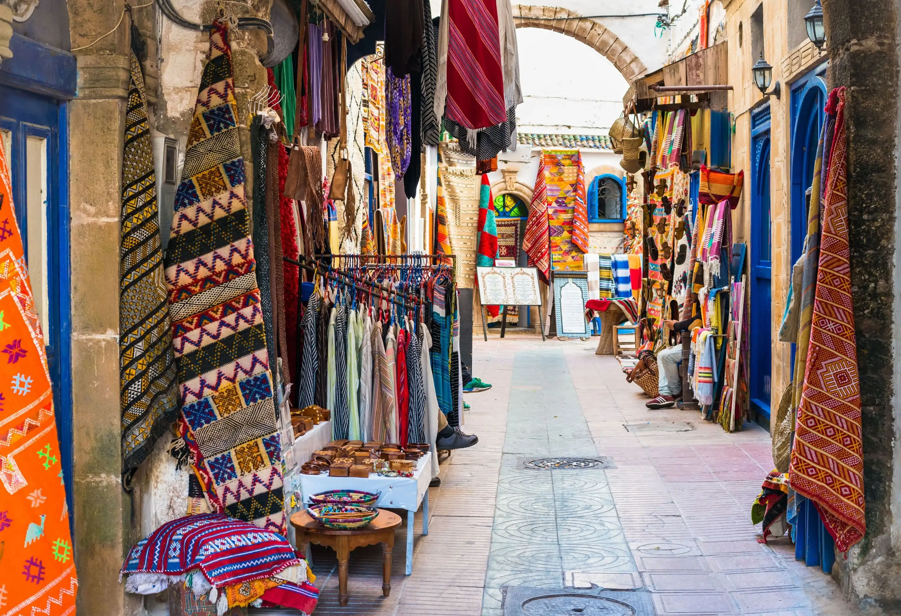 Exquisitely crafted textiles and garments on display in a street market.