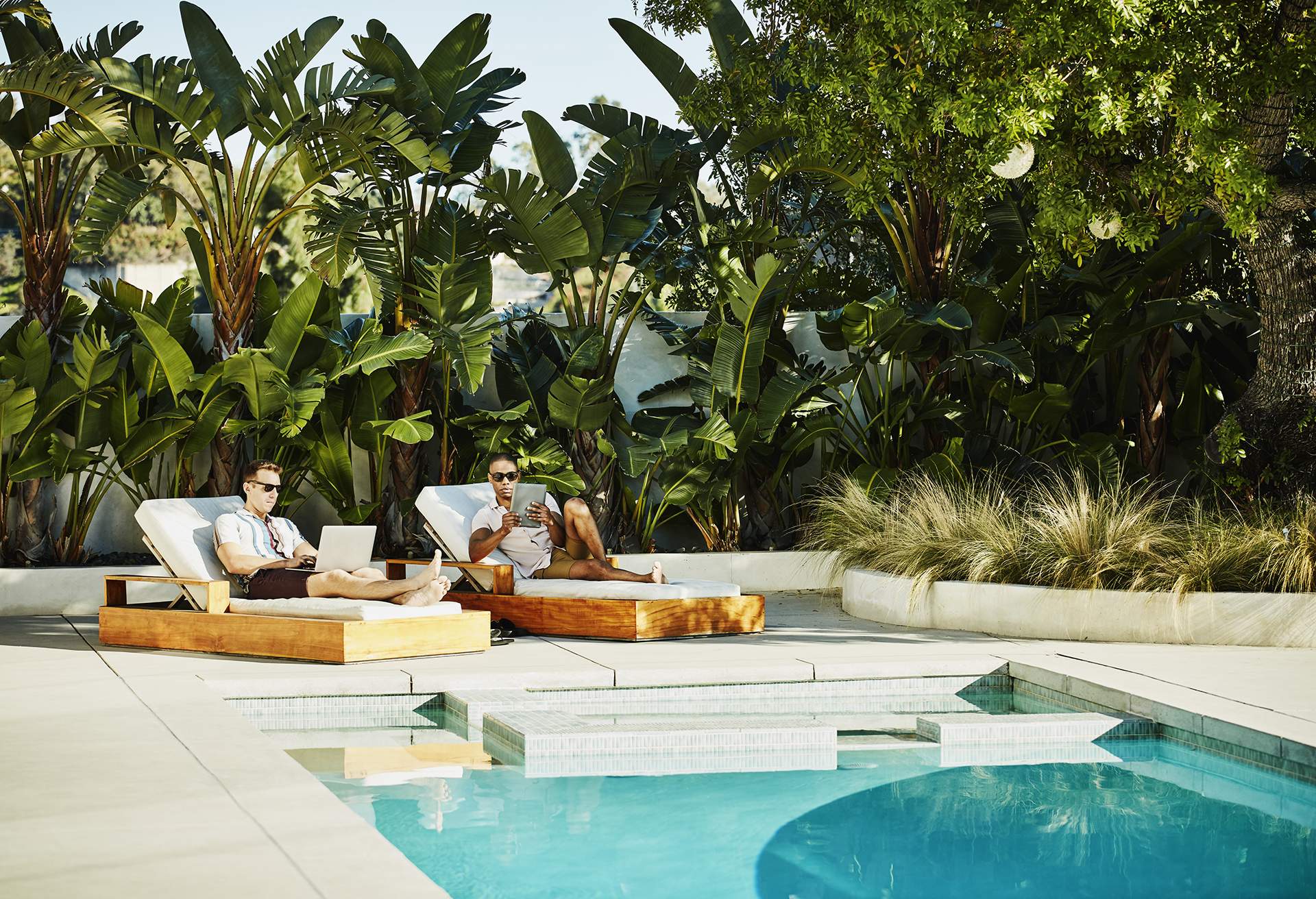 GAY LGBTQ COUPLE LYING BY THE POOL