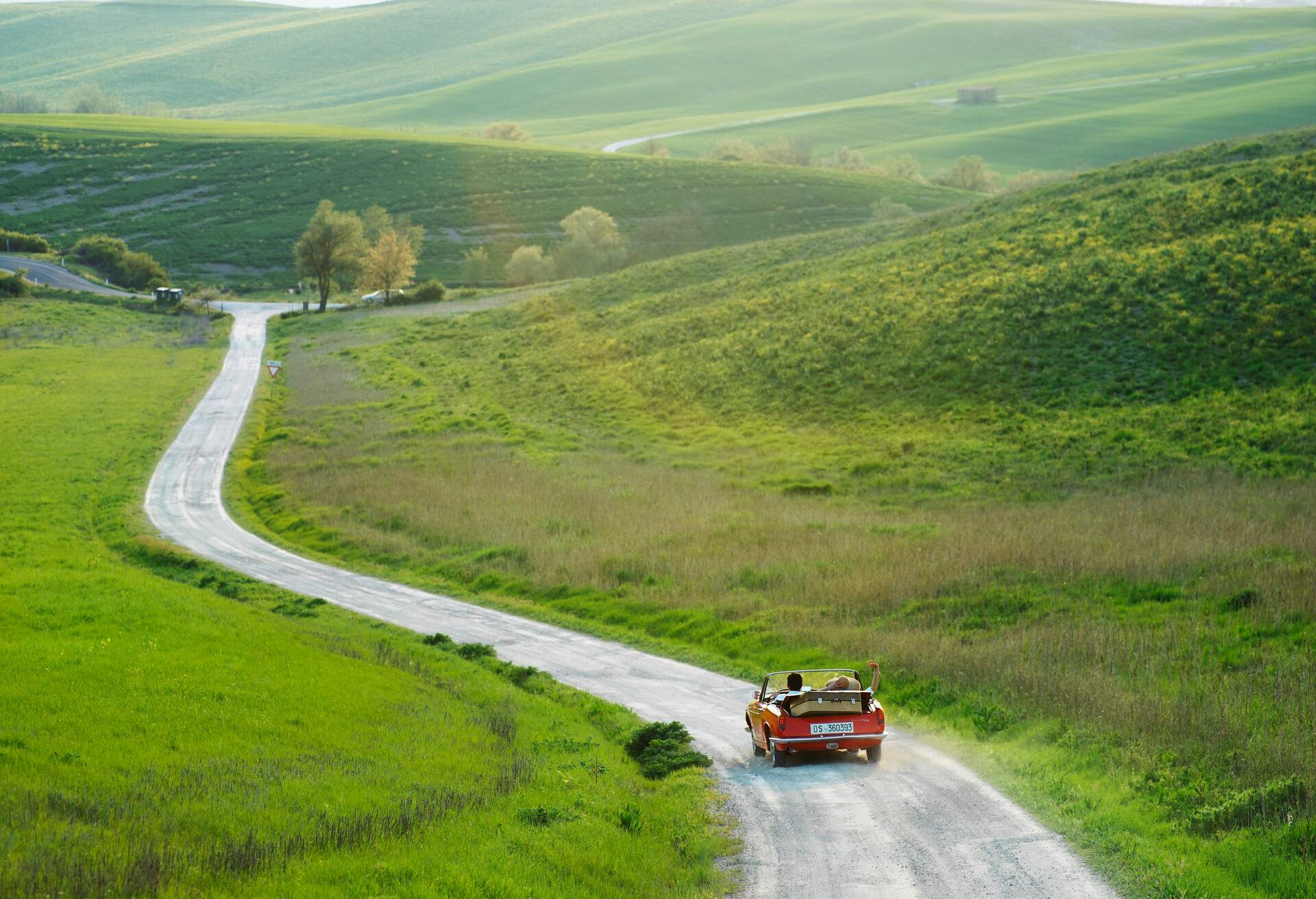 A red car driving on the Italian country side