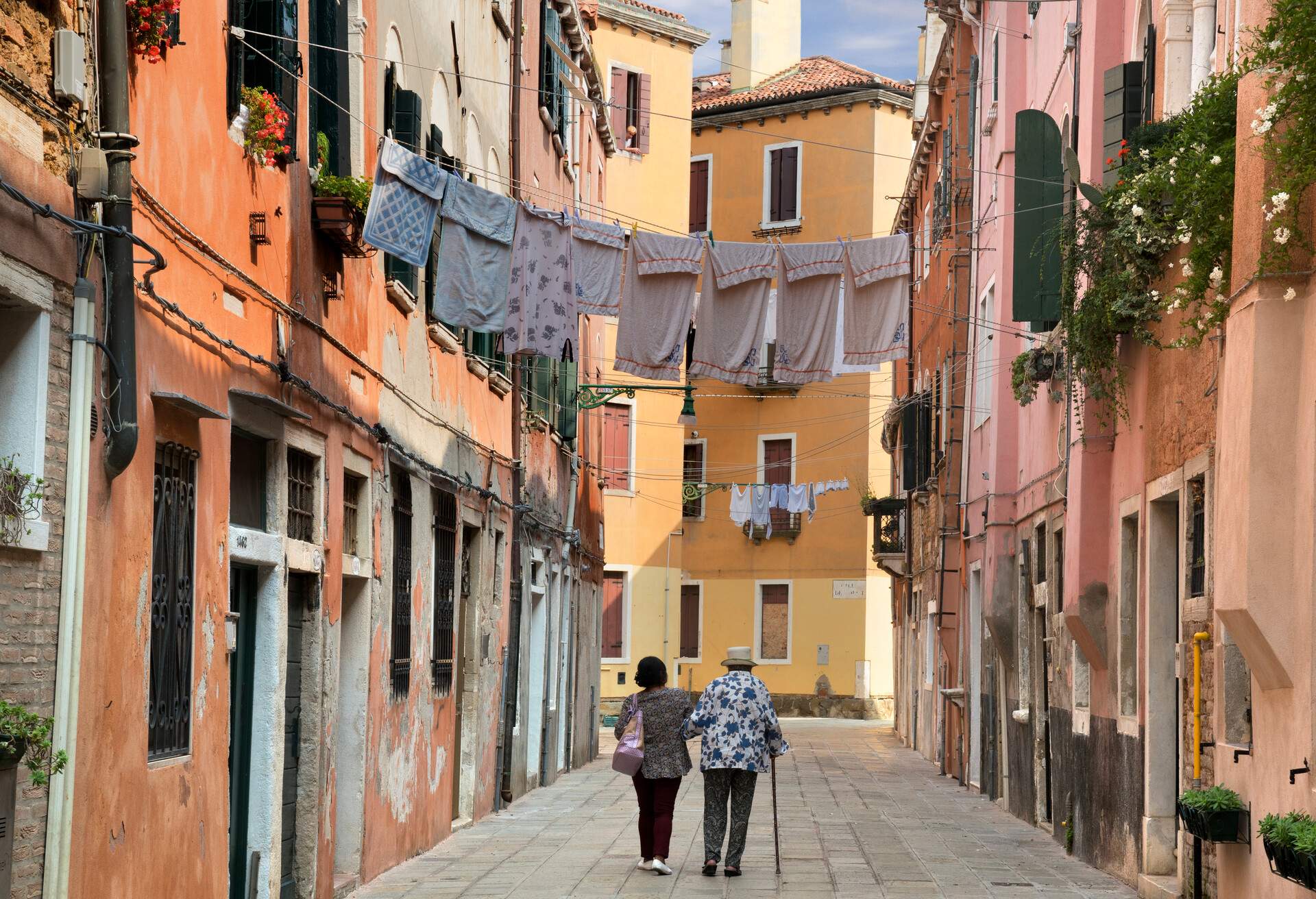 DEST_ITALY_VENICE_Two old women walking along Sotoportego de le Colone in Venice_GettyImages-855353558
