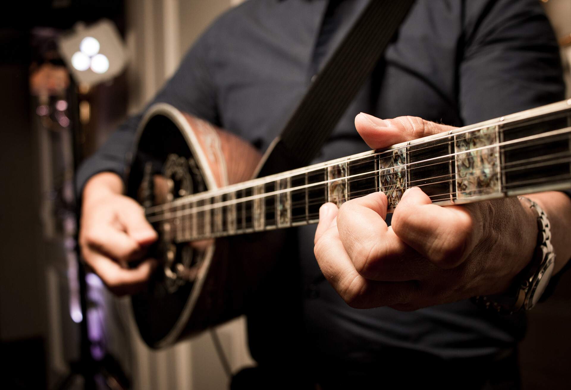 man playing a bouzouki guitar