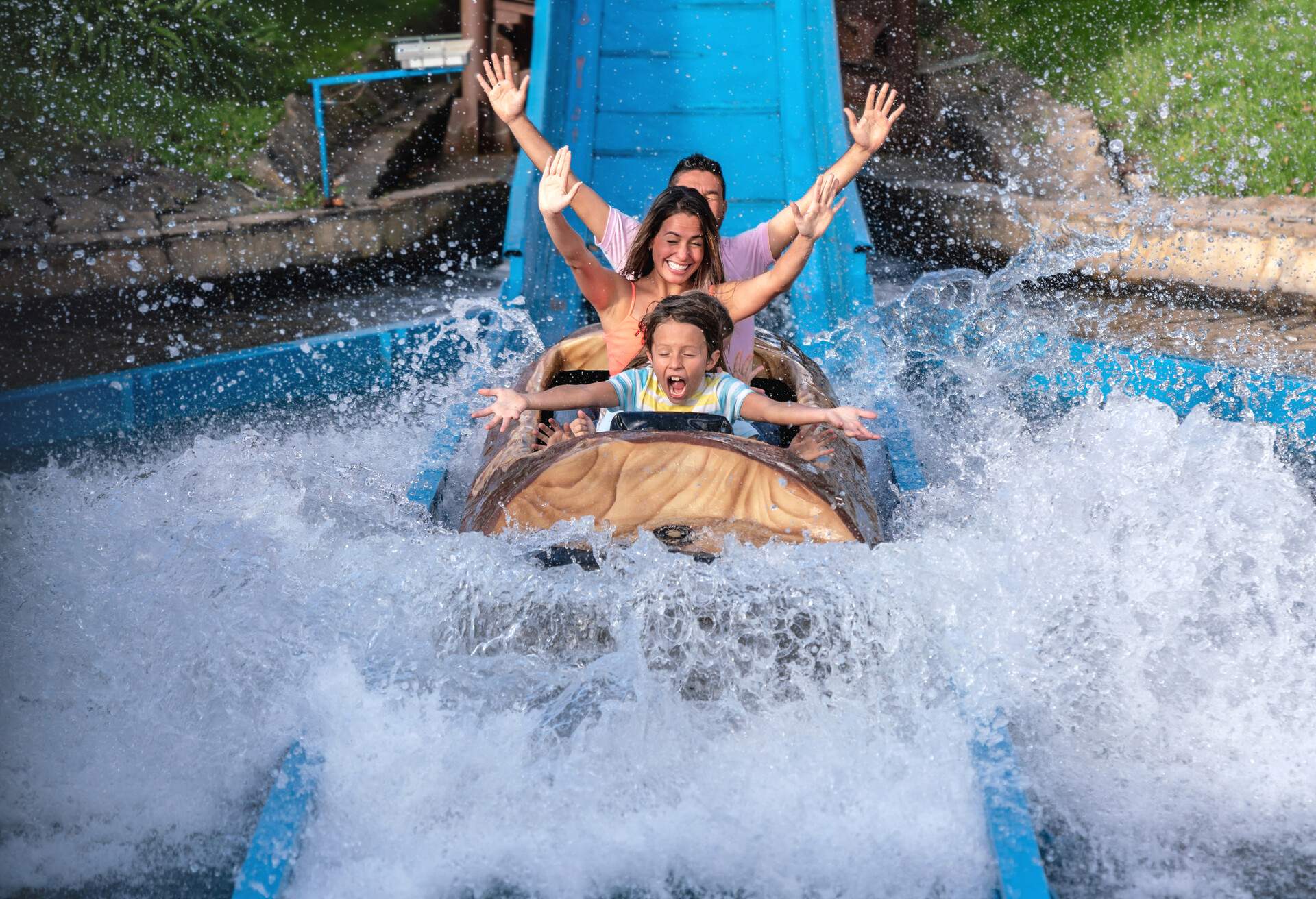 Happy family having fun in an amusement park riding on a fun water ride - lifestyle concepts.