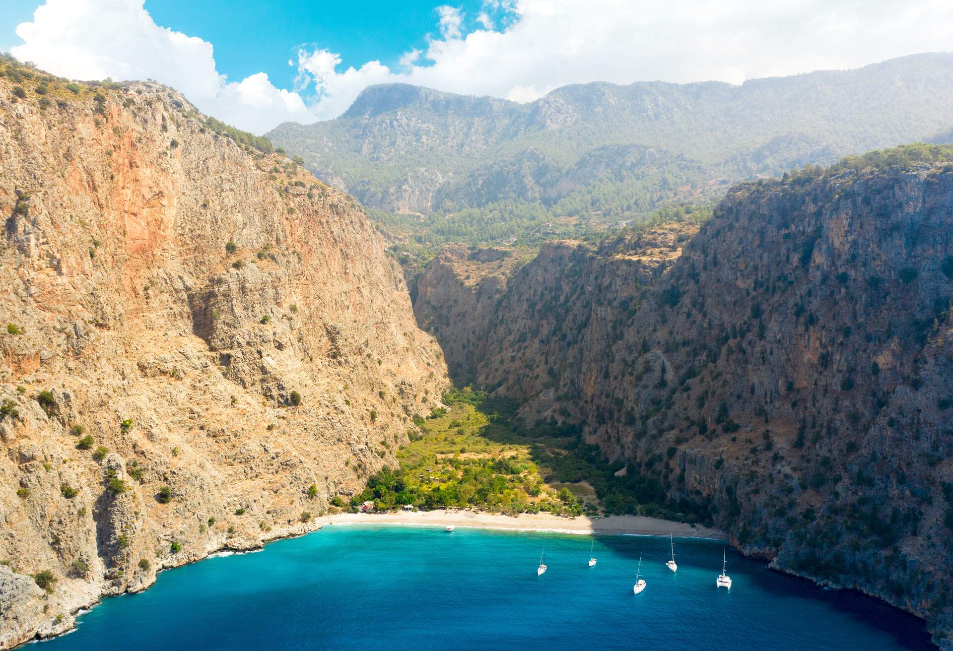 Aerial view over the clear beach and turquoise water of Butterfly Valley. In Turkish: Kelebekler Vadisi. Mugla Province, Turkey