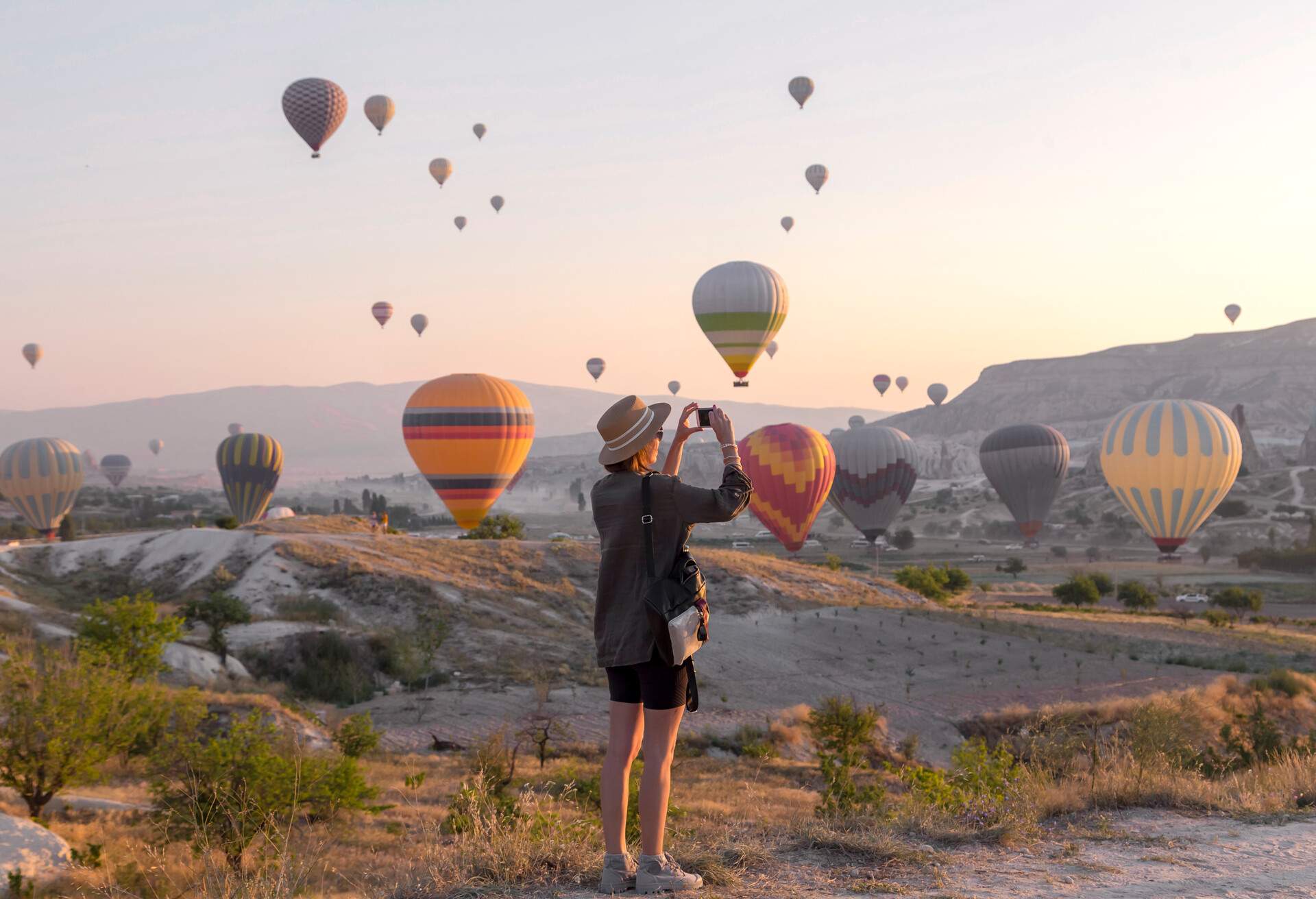 Young woman and hot air ballons, Goreme, Cappadocia, Turkey