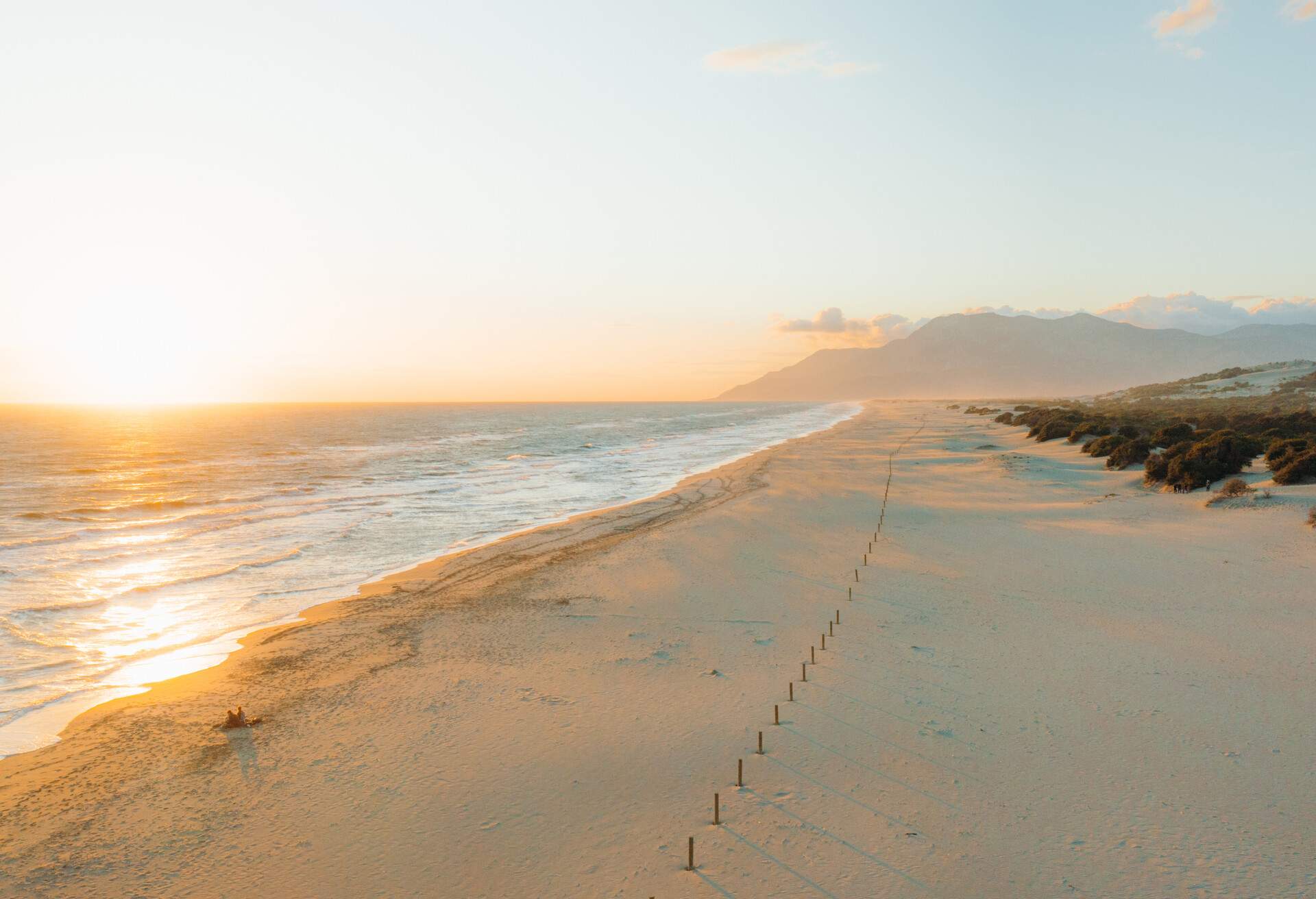 Drone panoramic photo of sand dune beach and the waved sea during bright colorful sunset at Patara, South Turkey