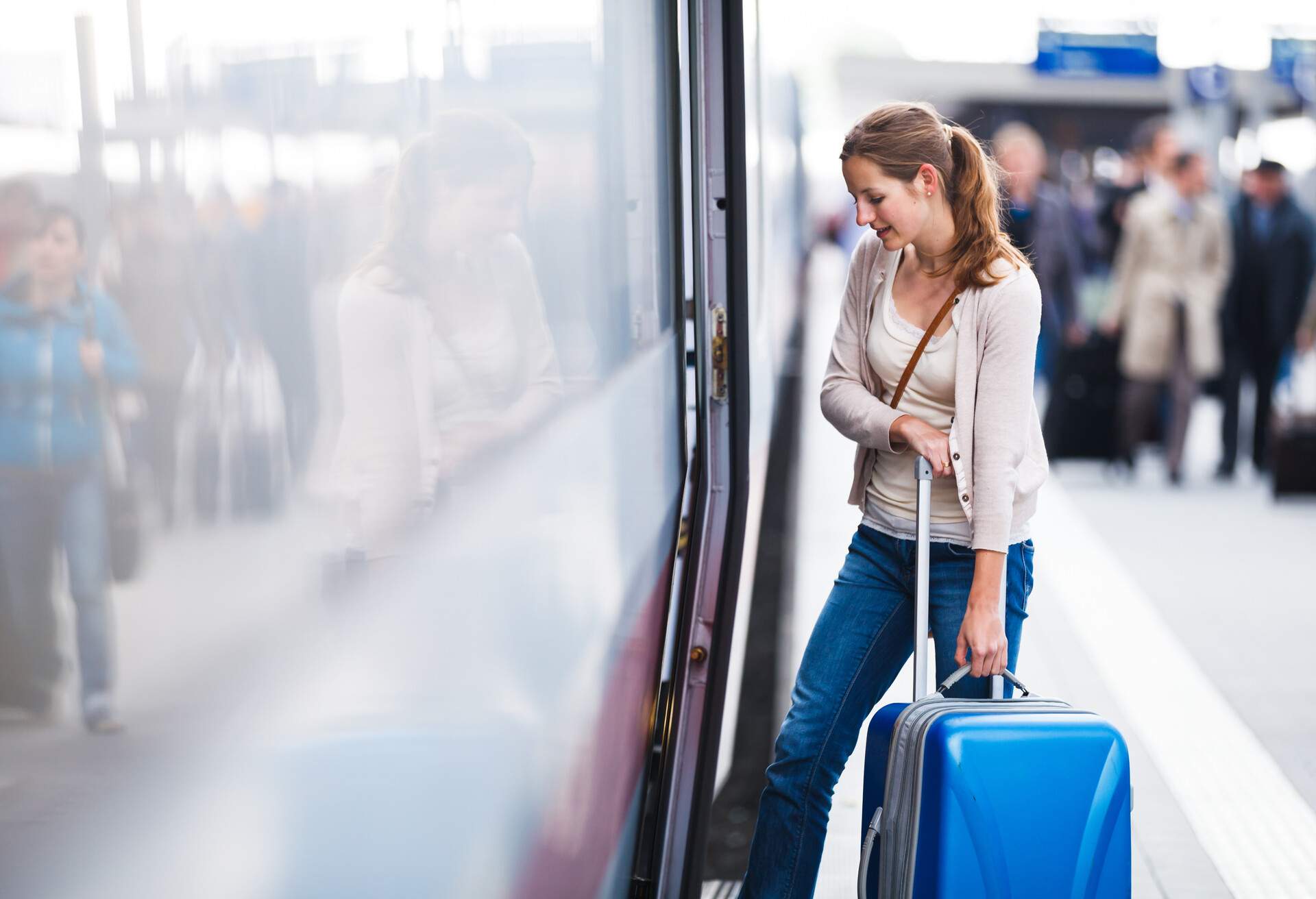 Pretty young woman at a train station; Shutterstock ID 115054240