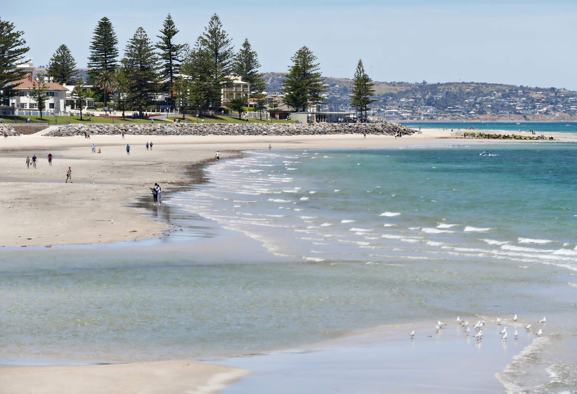 People enjoying themselves at Glenelg Beach on a spring day.