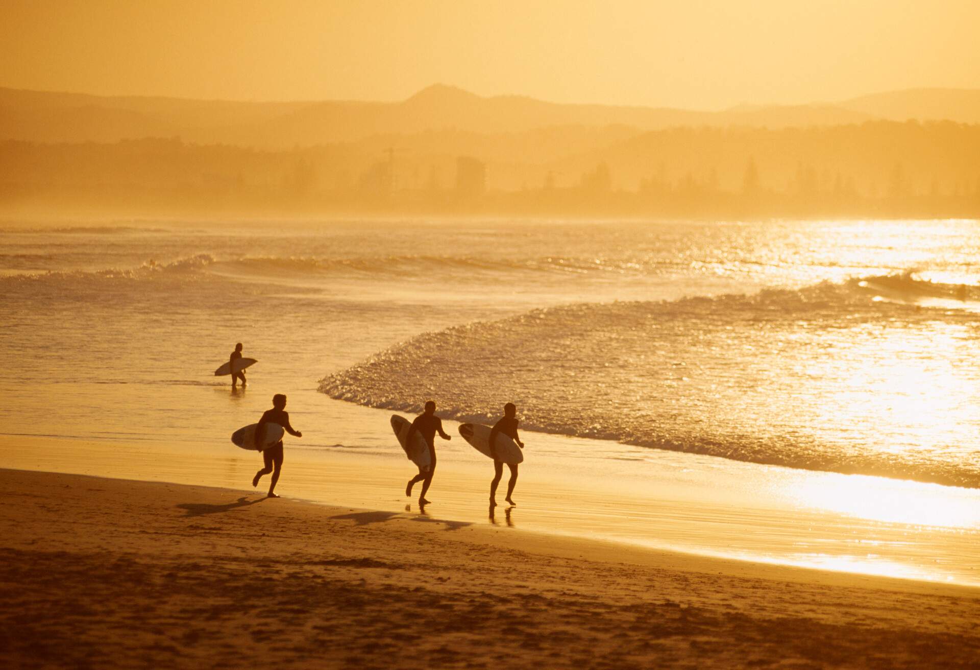 Surfer walking on beach, Surfer's paradise.