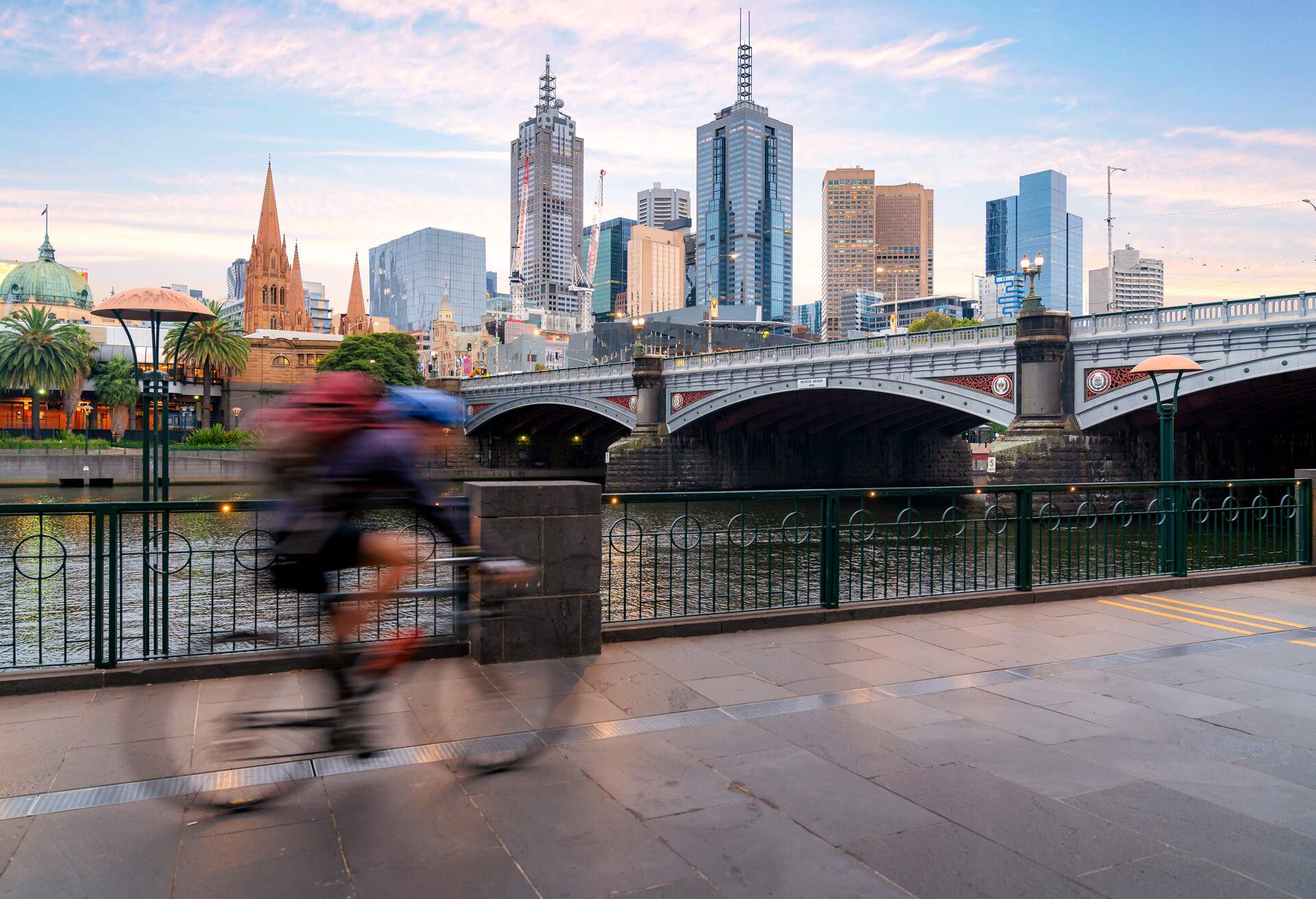 Australian people cycling  for exercise near Yarra River with view of the Melbourne City Financial District with skyscrapers in morning at Melbourne, Victoria, Australia.