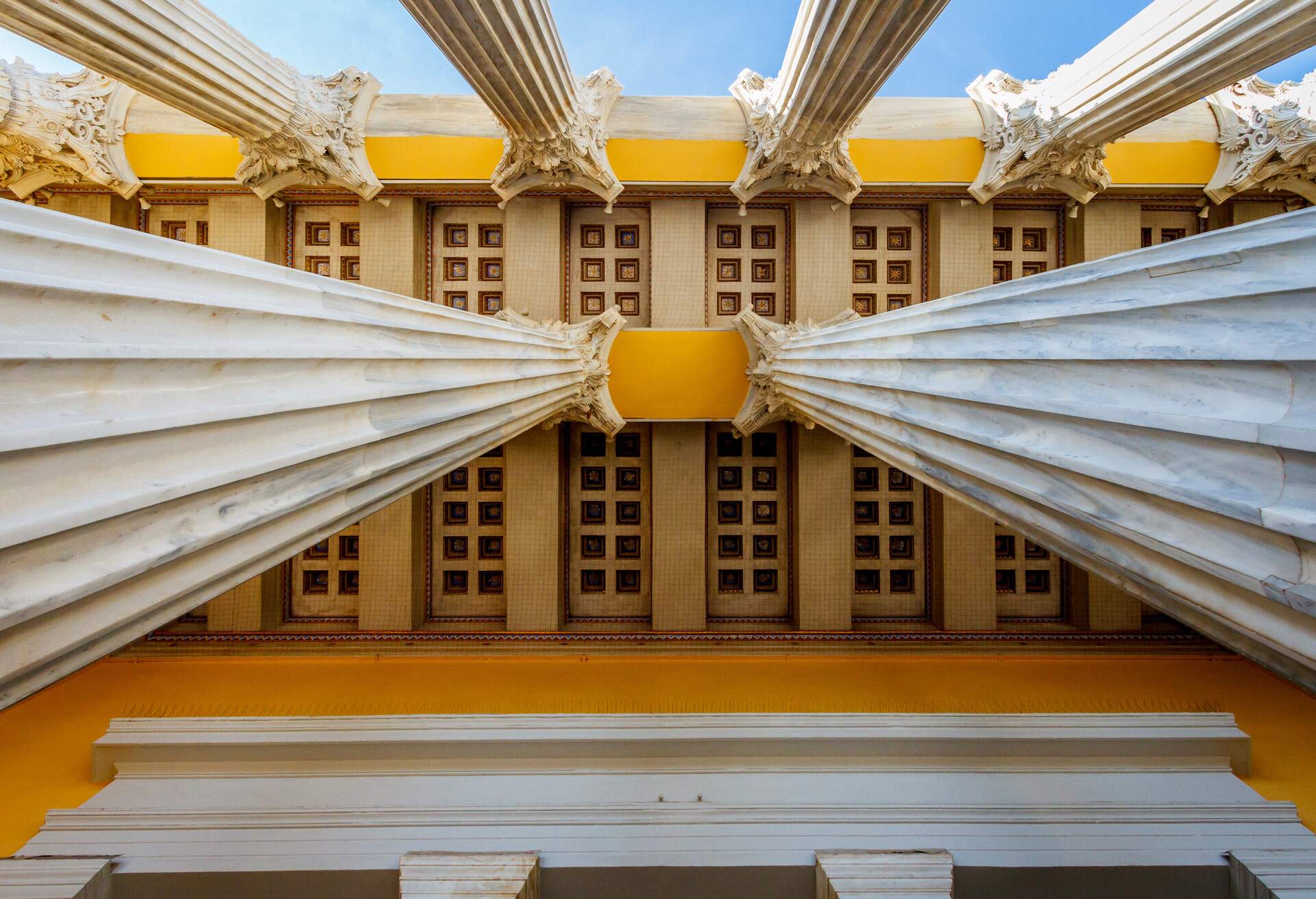 The ceiling of a building with columns is seen from below.