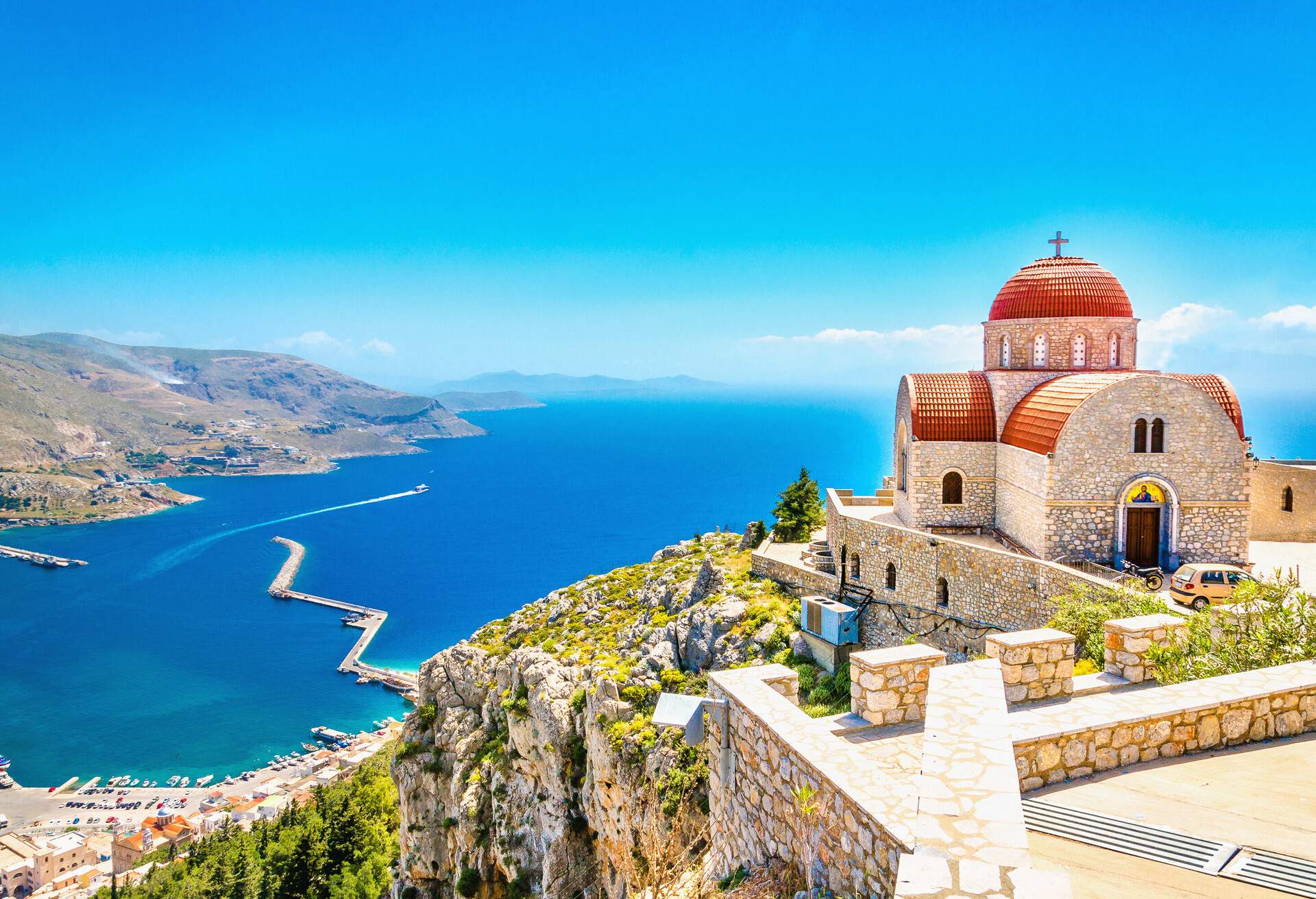 Amazing view on remote church with red roofing on the Cliff of the sea, Greece