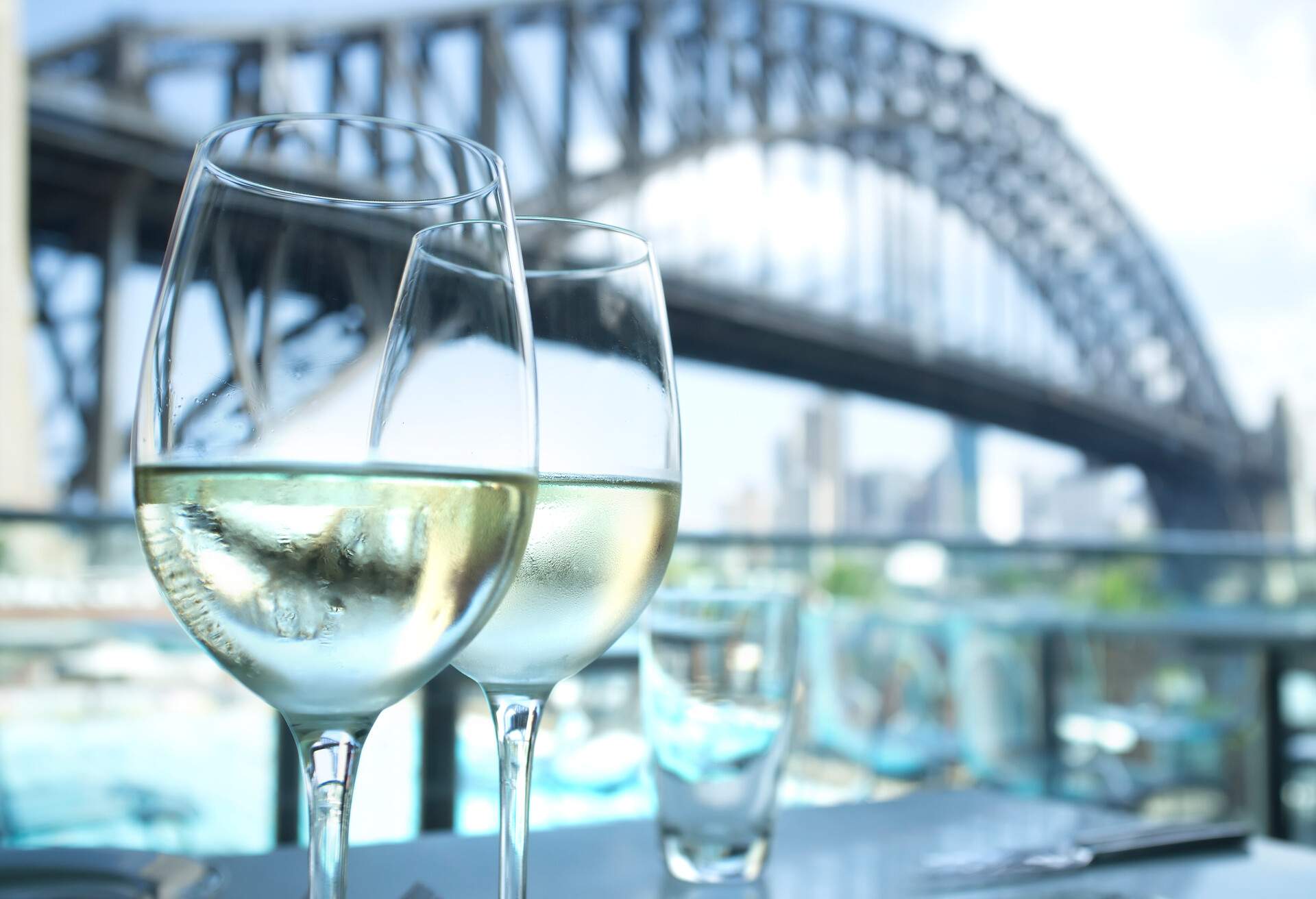 Wine glasses in a restaurant with Sydney Harbour Bridge in the background