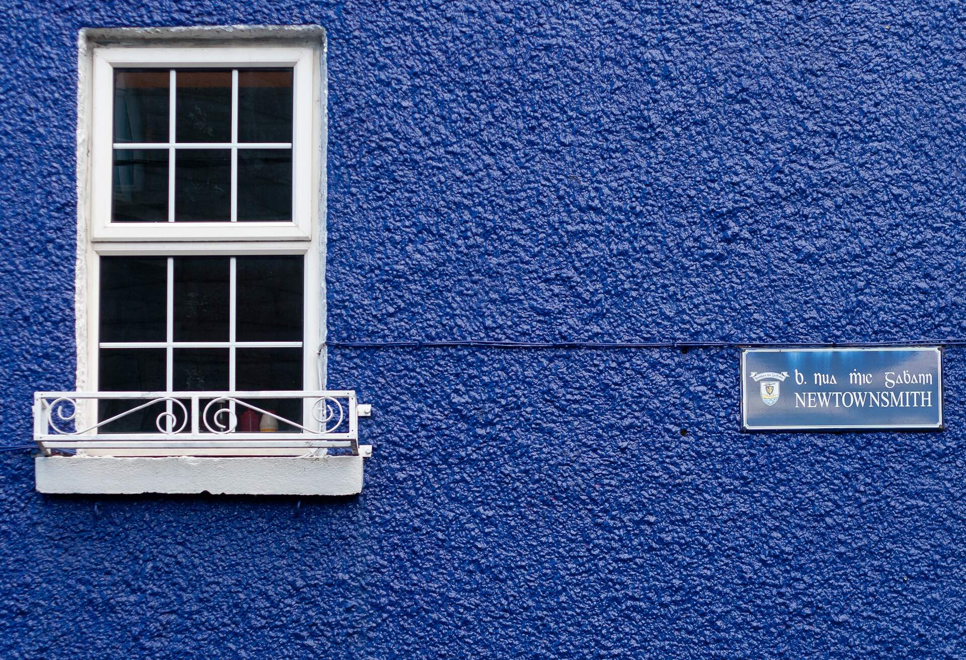A white window in a blue building in Galway, Republic of Ireland