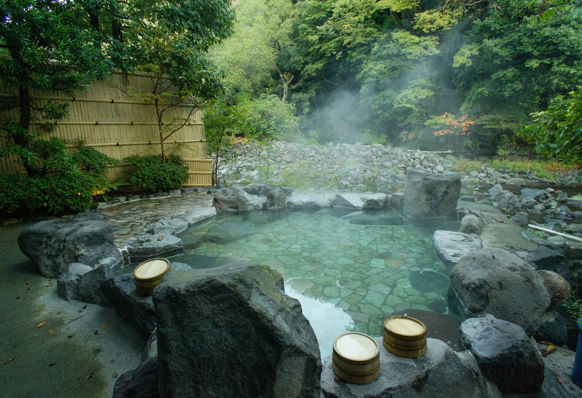 Traditional Japanese natural hot spring bath (Onsen) next to a river in forest, Hakone, Kanagawa, Japan