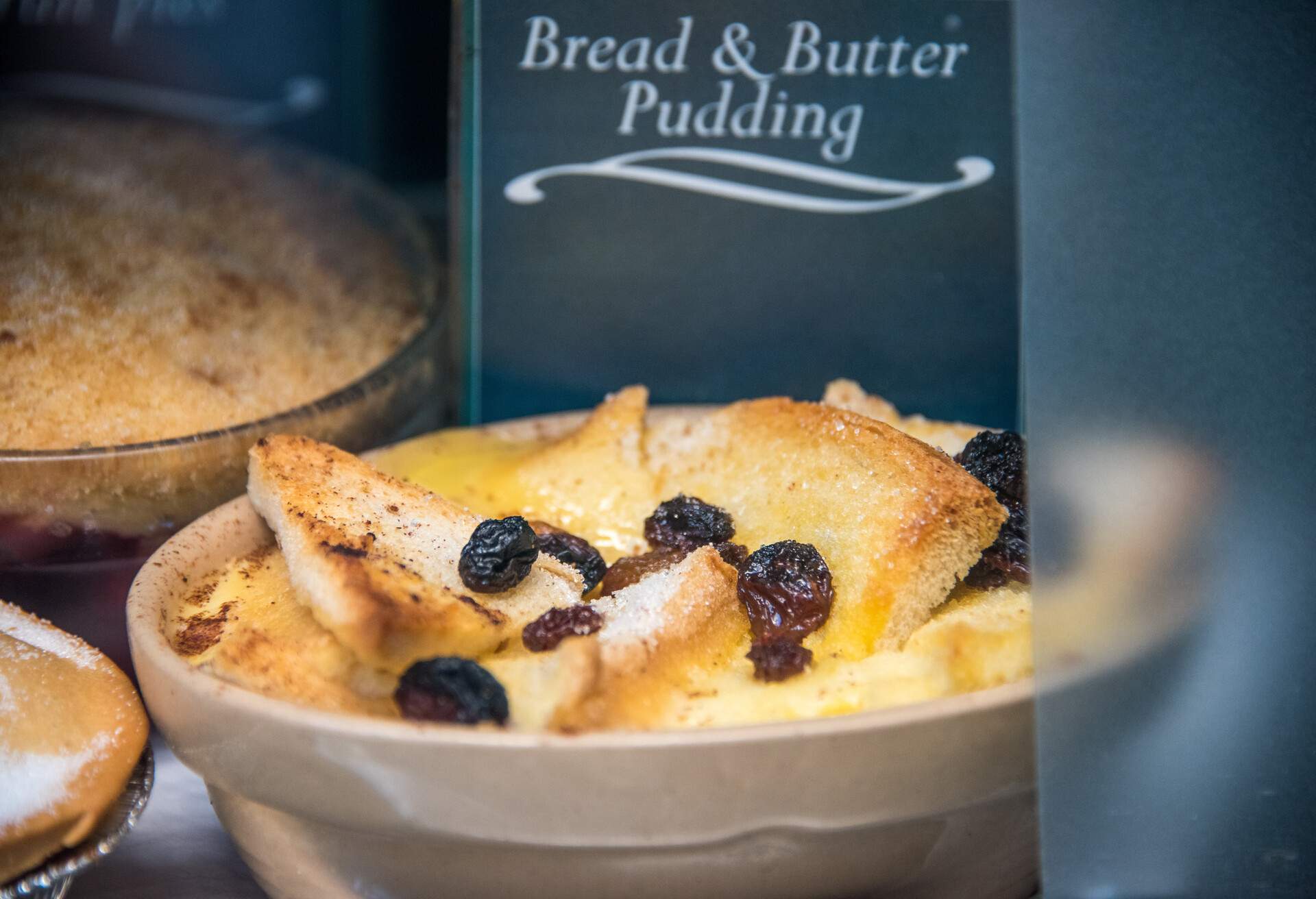 Close up of a Bread & Butter Pudding on display with name tag in a traditional English restaurant window in East London, UK