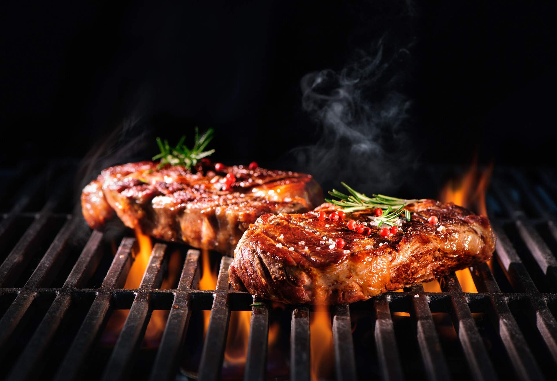 Beef steaks on the grill with flames