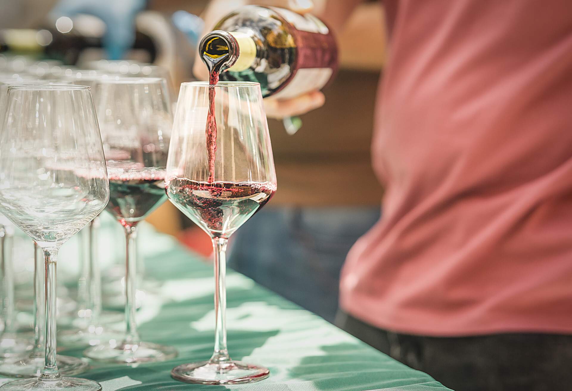 Man's hand pouring glasses of red wine