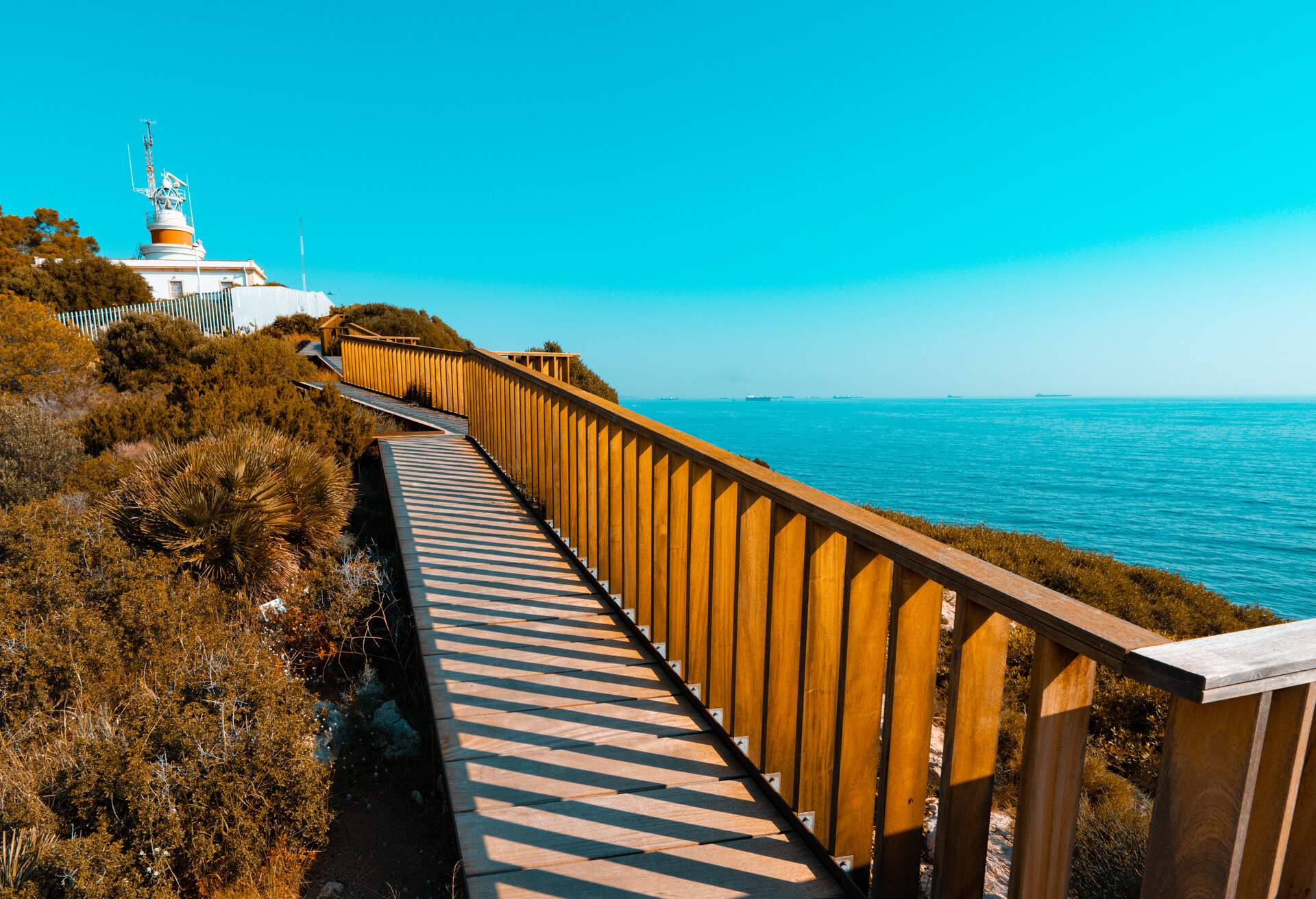 Vanishing point to old lighthouse of Salou in Costa Daurada. Mediterranean sea coast in Spain. Orange and teal style.