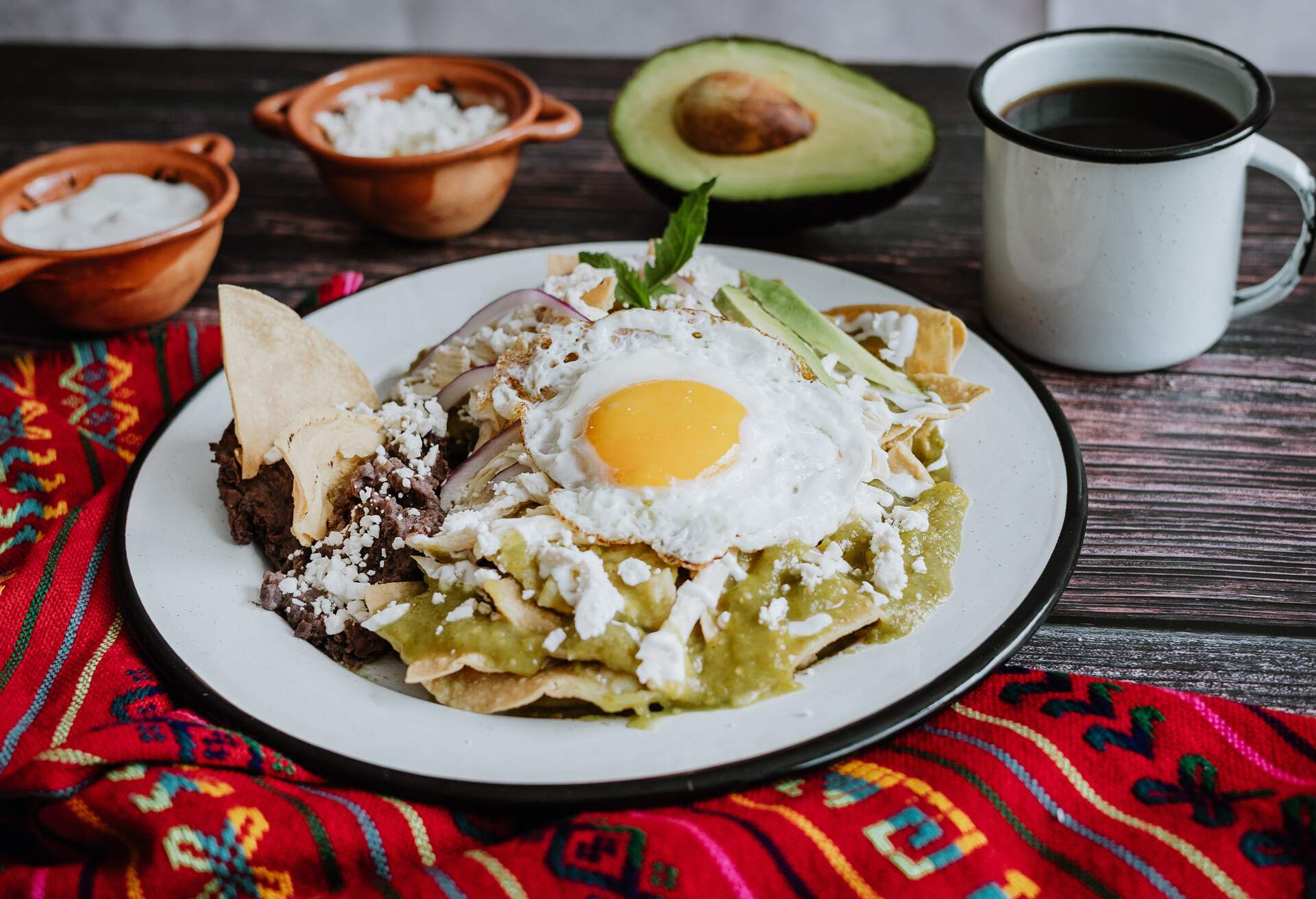 mexican chilaquiles with fried egg, chicken and spicy green sauce traditional breakfast in Mexico