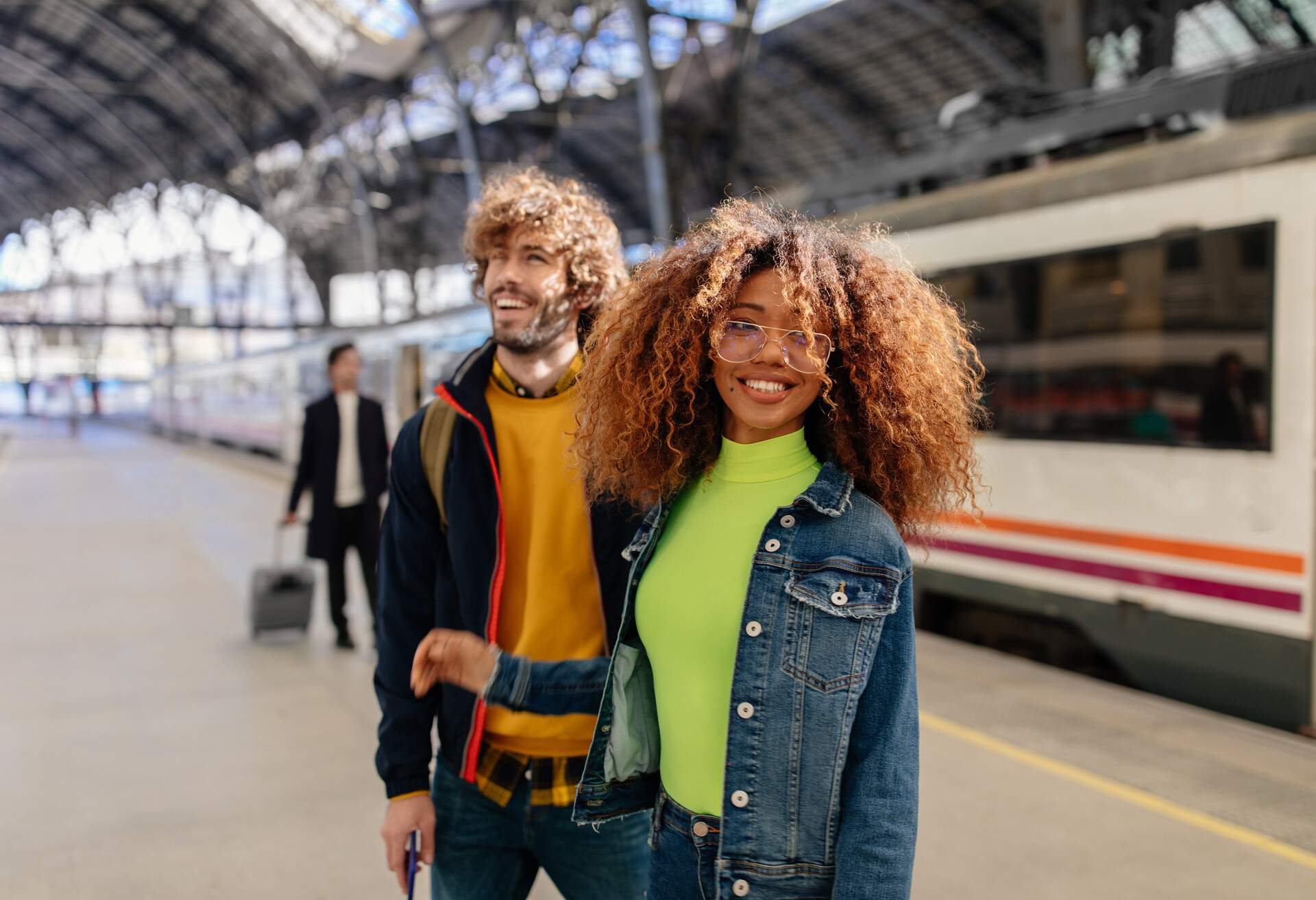 Young multi-ethnic couple waiting for train on platform at train station in Spain