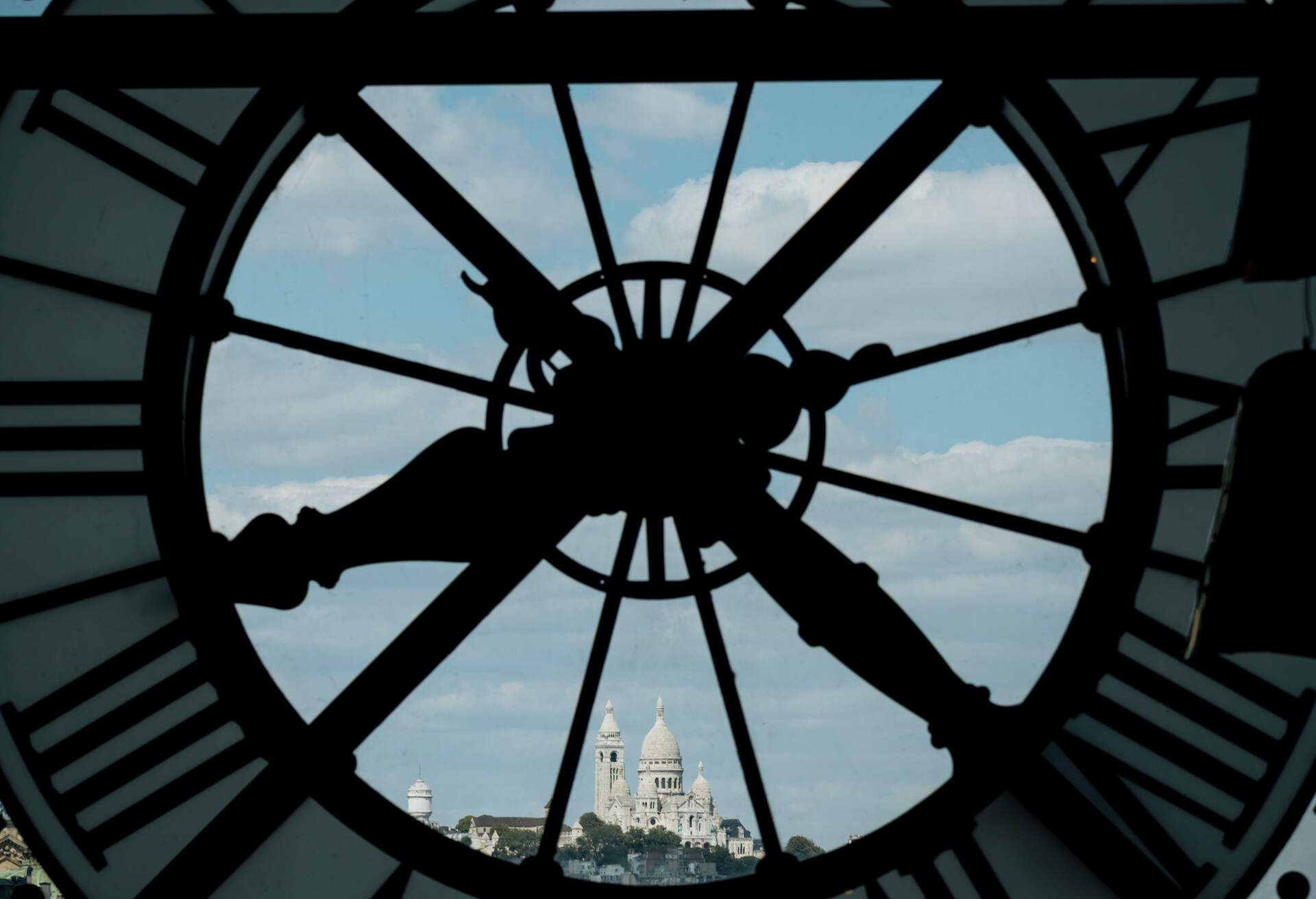 France, Paris, Close-up of clock with Basilique du Sacre Coeur in distance