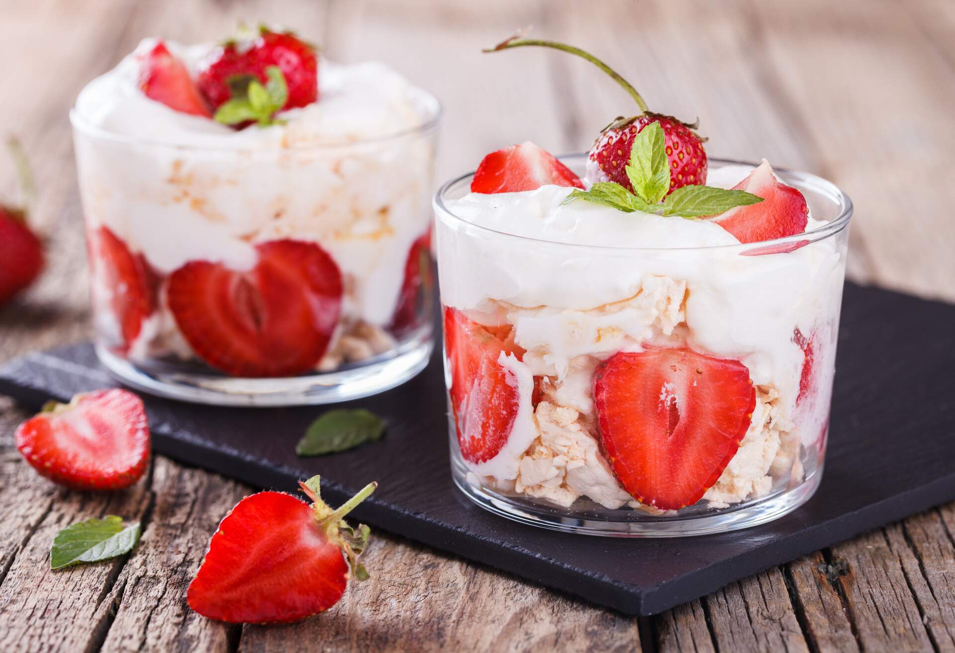 Eton Mess - Strawberries with whipped cream and meringue in a glass beaker. Classic British summer dessert.selective focus