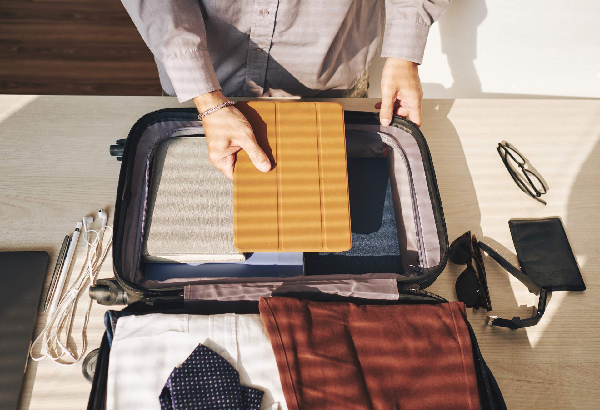 man packing suitcase for business