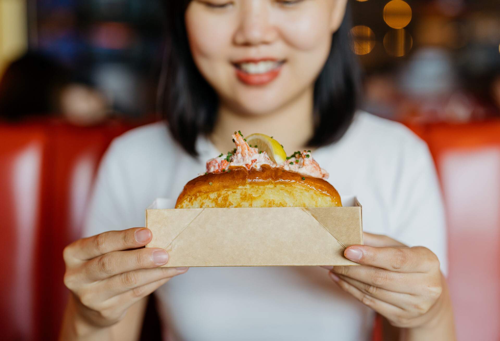 PEOPLE_WOMAN_EATING-LOBSTER_ROLL_RESTAURANT