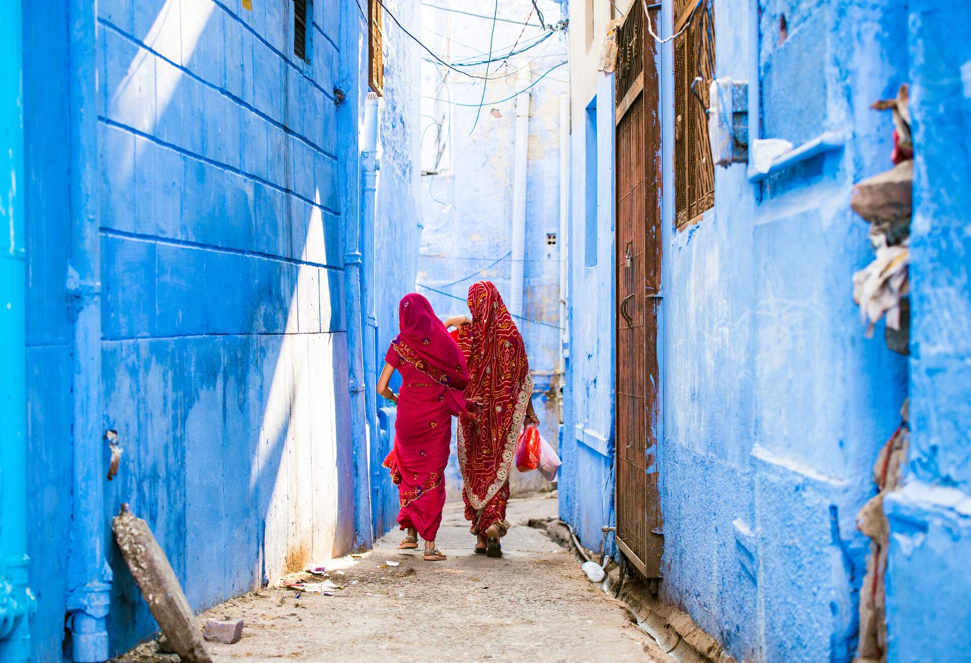 Two women in Indian Saree walking through narrow streets of Jodhpur, Rajasthan, India
