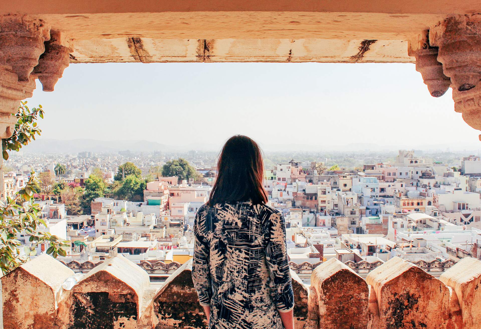 A young woman looks out over the city of Udaipur, Rajasthan, North India