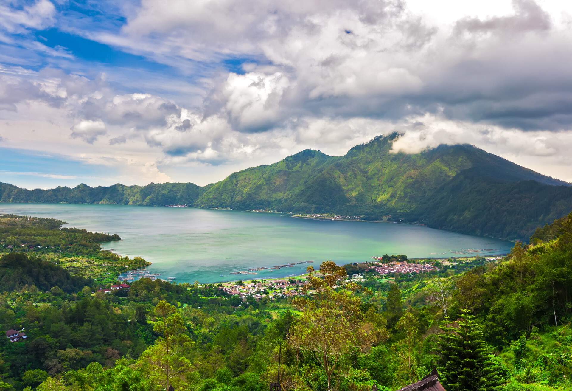 Panoramic view of a lake surrounded by mountain, tropical landscape with colorful clouds in the sky. Danau Batur, Gunung Batur, Kintamani, Bali, Indonesia.