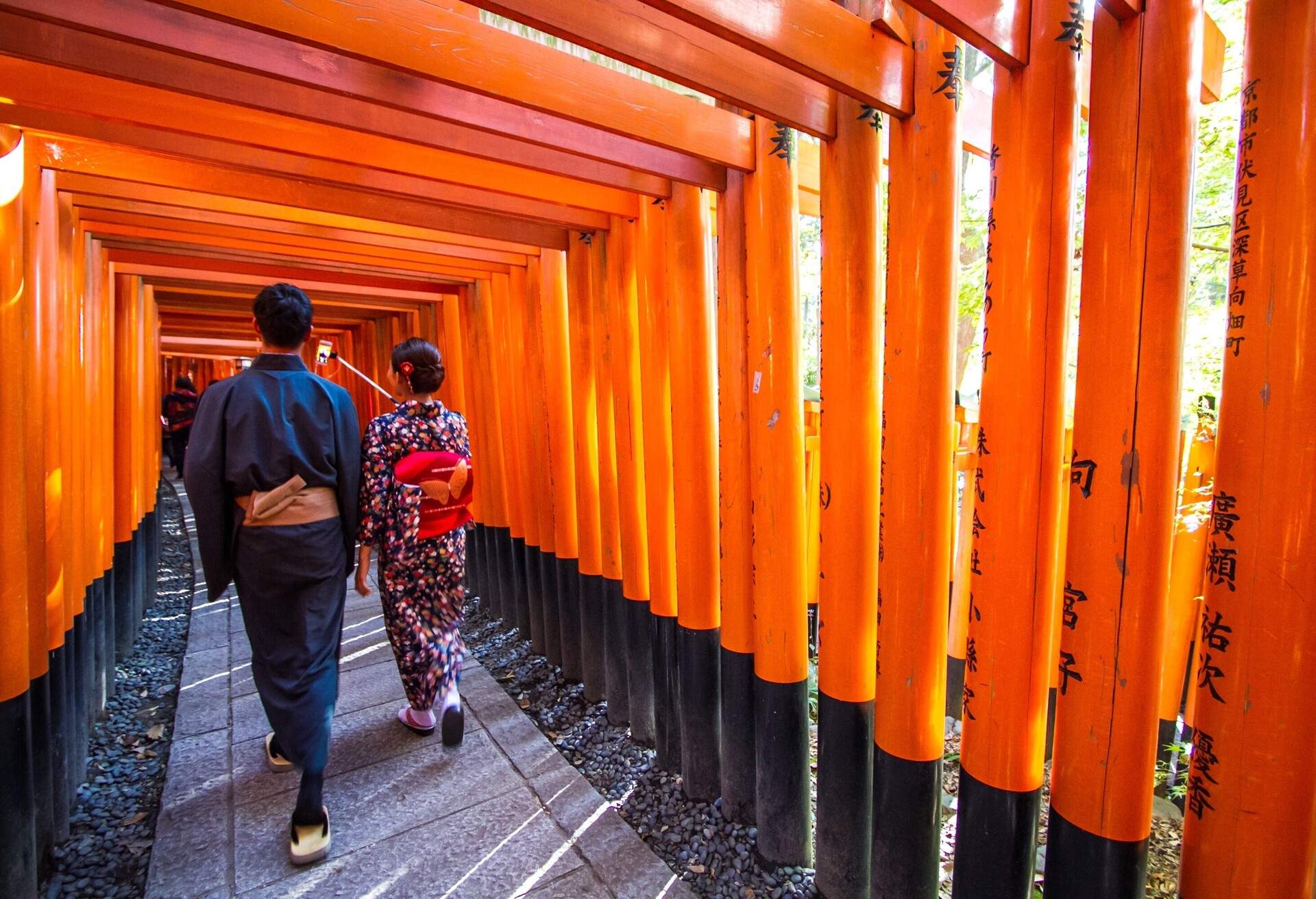 Tourists admiring the structure of Fushimi Inari Taisha Shrine.