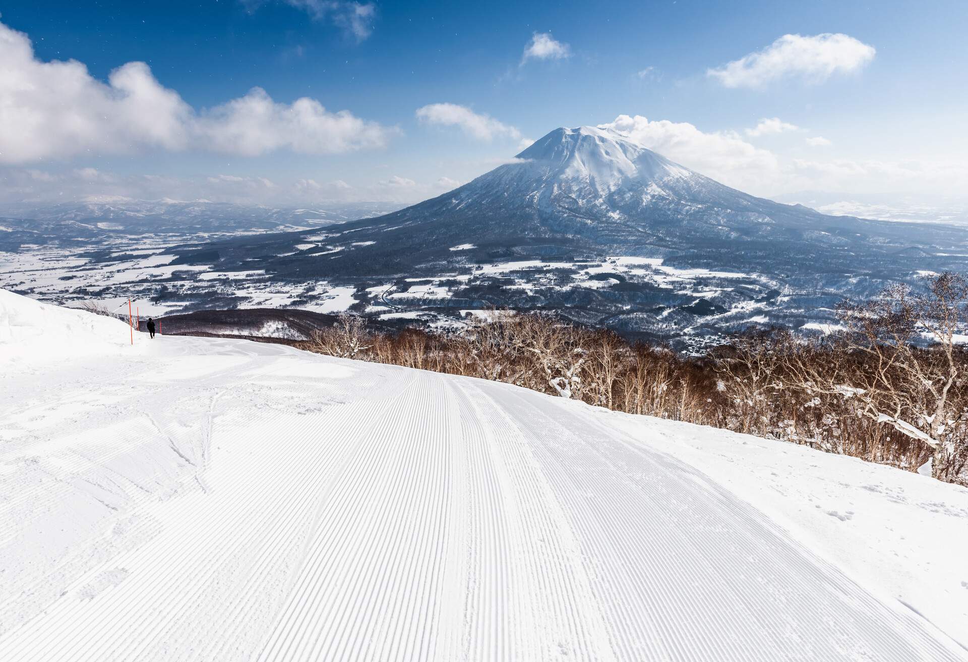 The ski cable car at Niseko Village Ski resort in Hokkaido Japan on a clear sunny day. Niseko is one of Hokkaido's most popular ski resorts. The dormant volcano of Mt Yotei dominates the background.