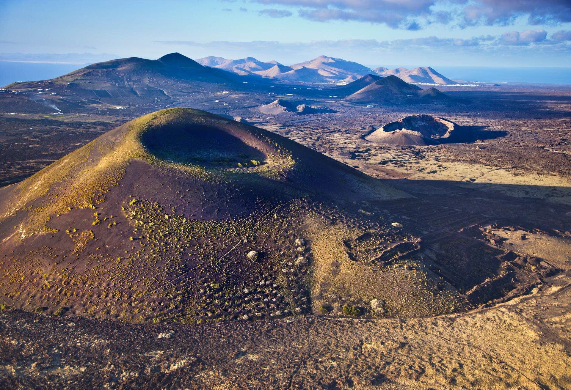 In the foreground Negra Mountain. Behind Raven Volcano. In the background Timanfaya National Park. Lanzarote. Canary Islands. Spain. Europe.  Biosphere Reserve by UNESCO.