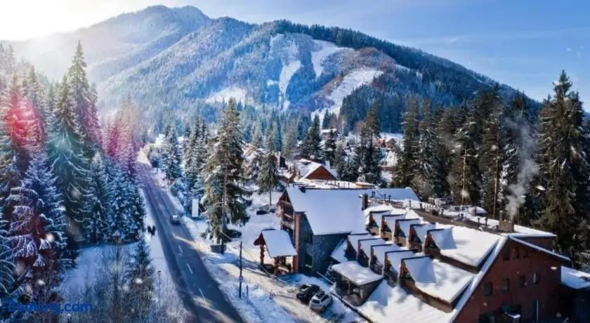 wooden ski resort in a snow landscape with mountains in the background